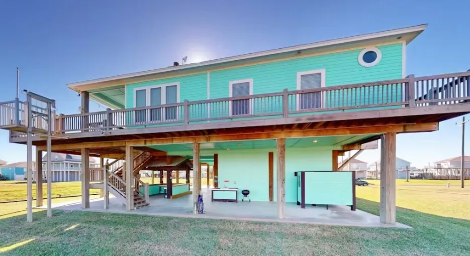 Rear view of house with a deck, stairway, and a yard