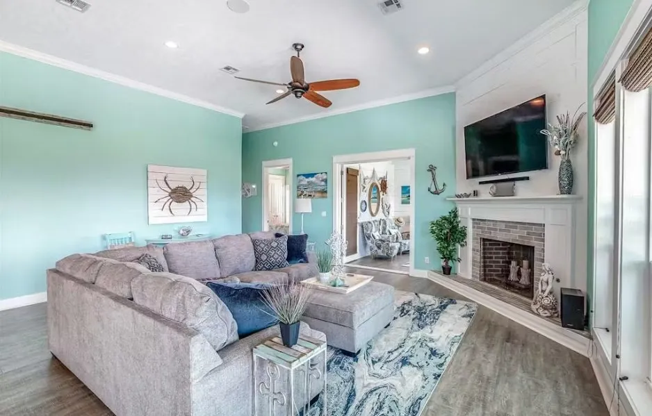 Living area featuring ornamental molding, a fireplace with raised hearth, ceiling fan, wood finished floors, and recessed lighting