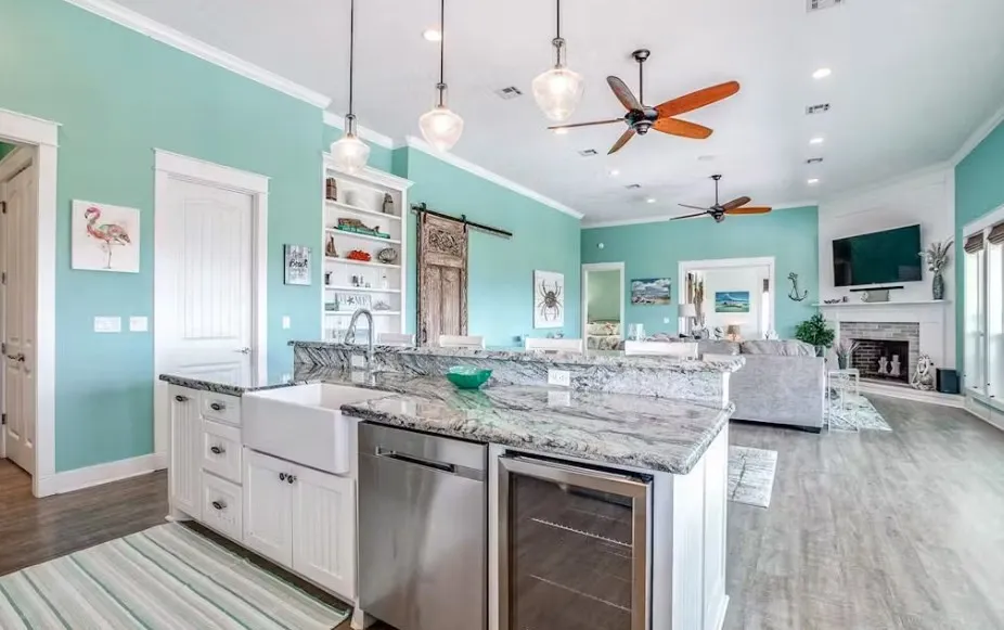 Kitchen featuring a barn door, white cabinets, light stone countertops, beverage cooler, and stainless steel dishwasher