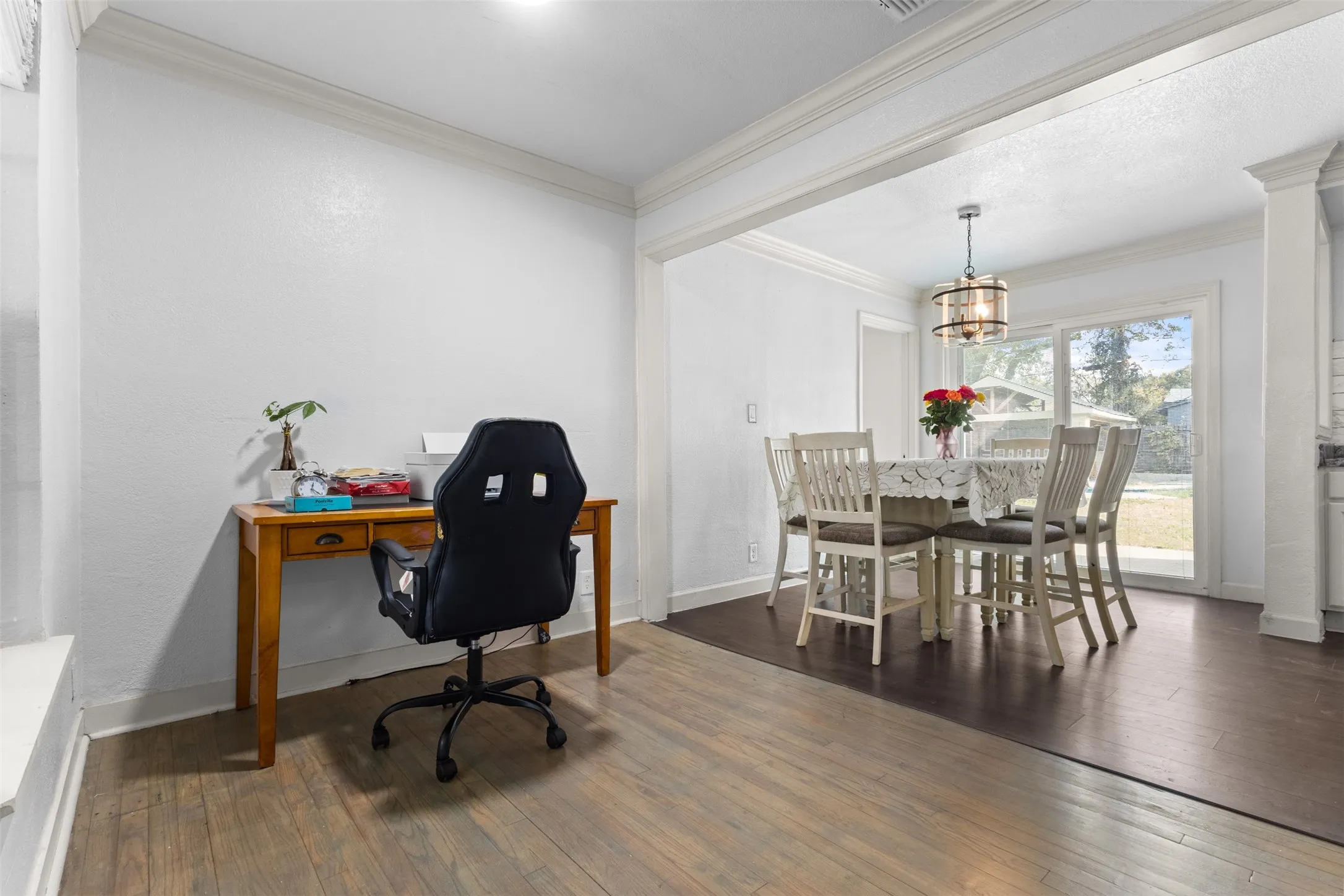 Office with dark wood finished floors, ornamental molding, and a chandelier