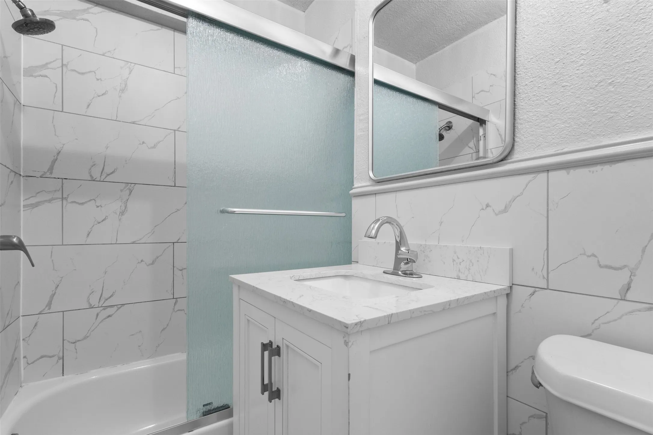 Full bathroom with enclosed tub / shower combo and vanity