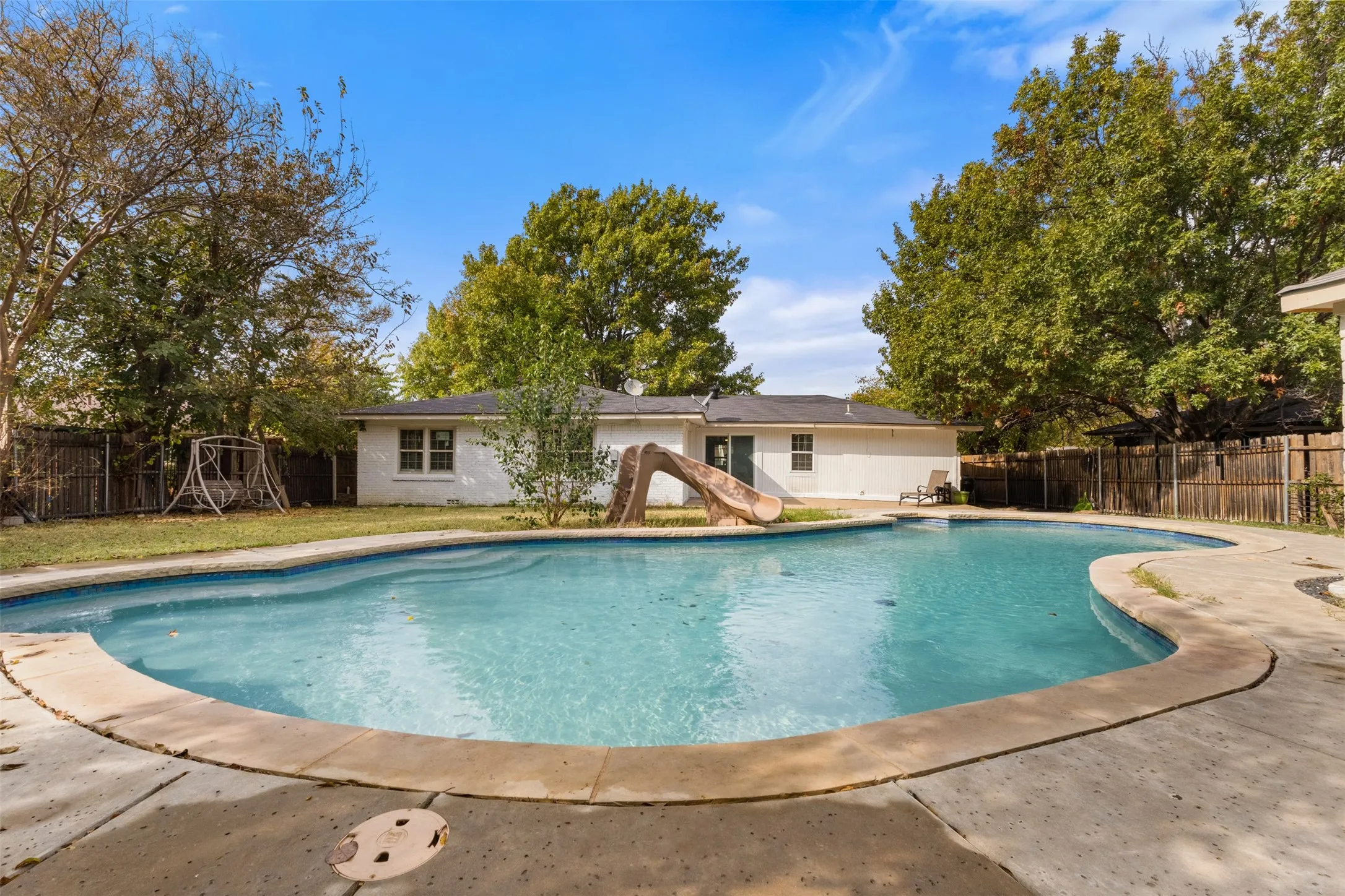 View of pool featuring a fenced backyard, a patio area, and a water slide