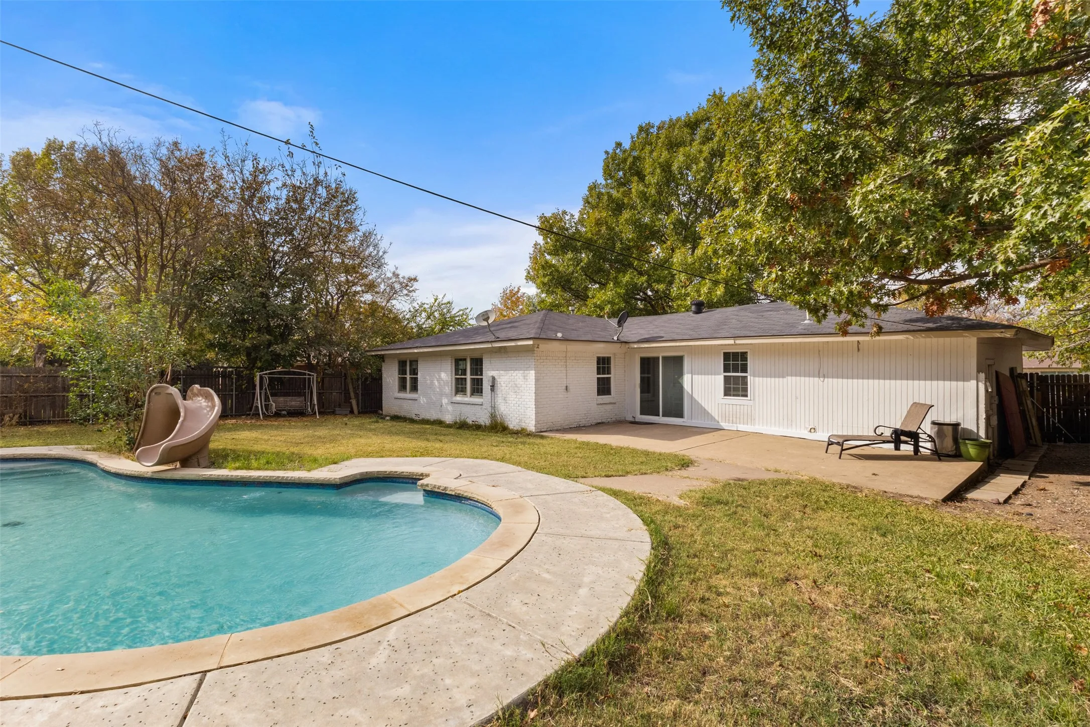 Rear view of property with a patio, a fenced backyard, and brick siding