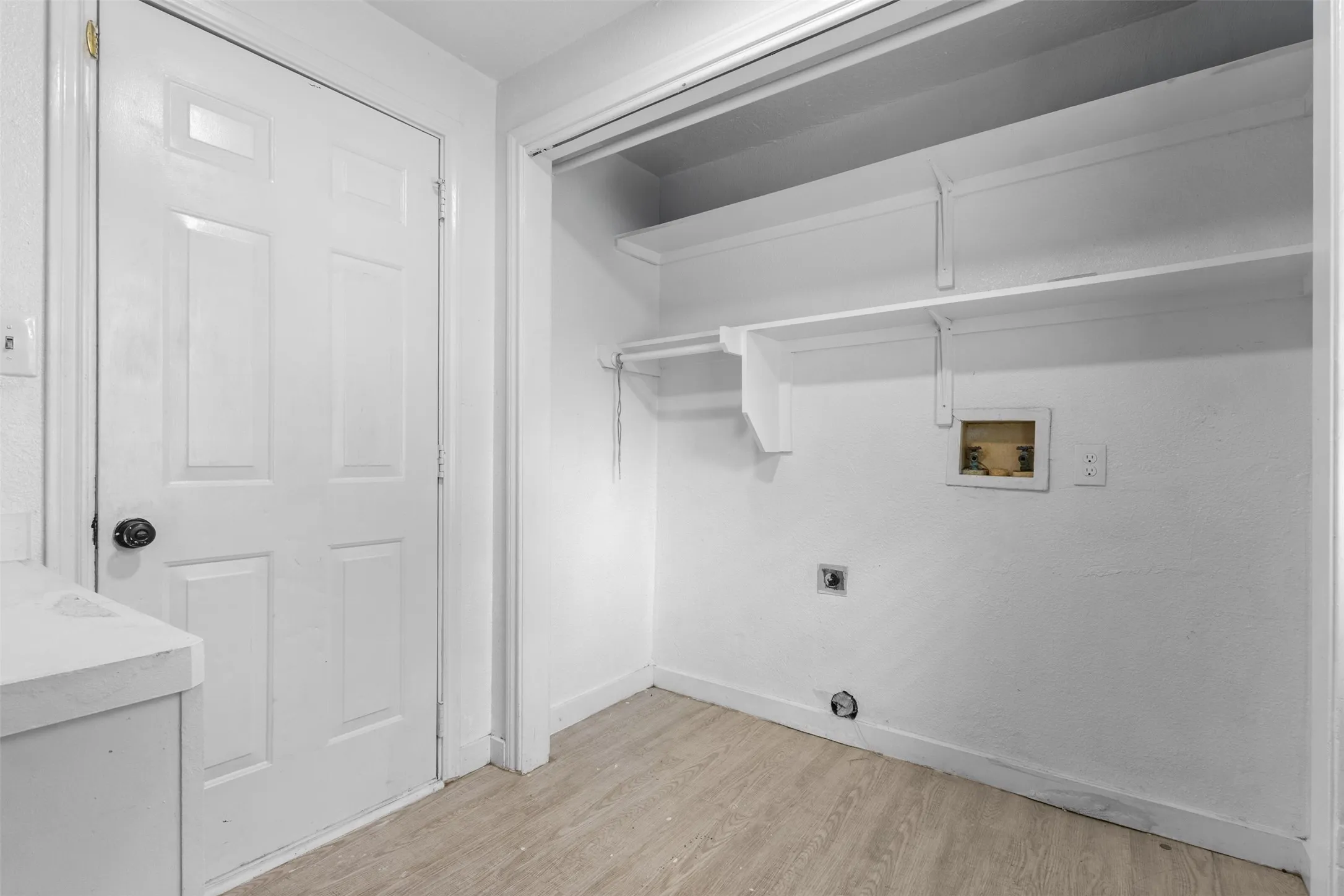 Laundry area featuring light wood-style floors, washer hookup, and electric dryer hookup