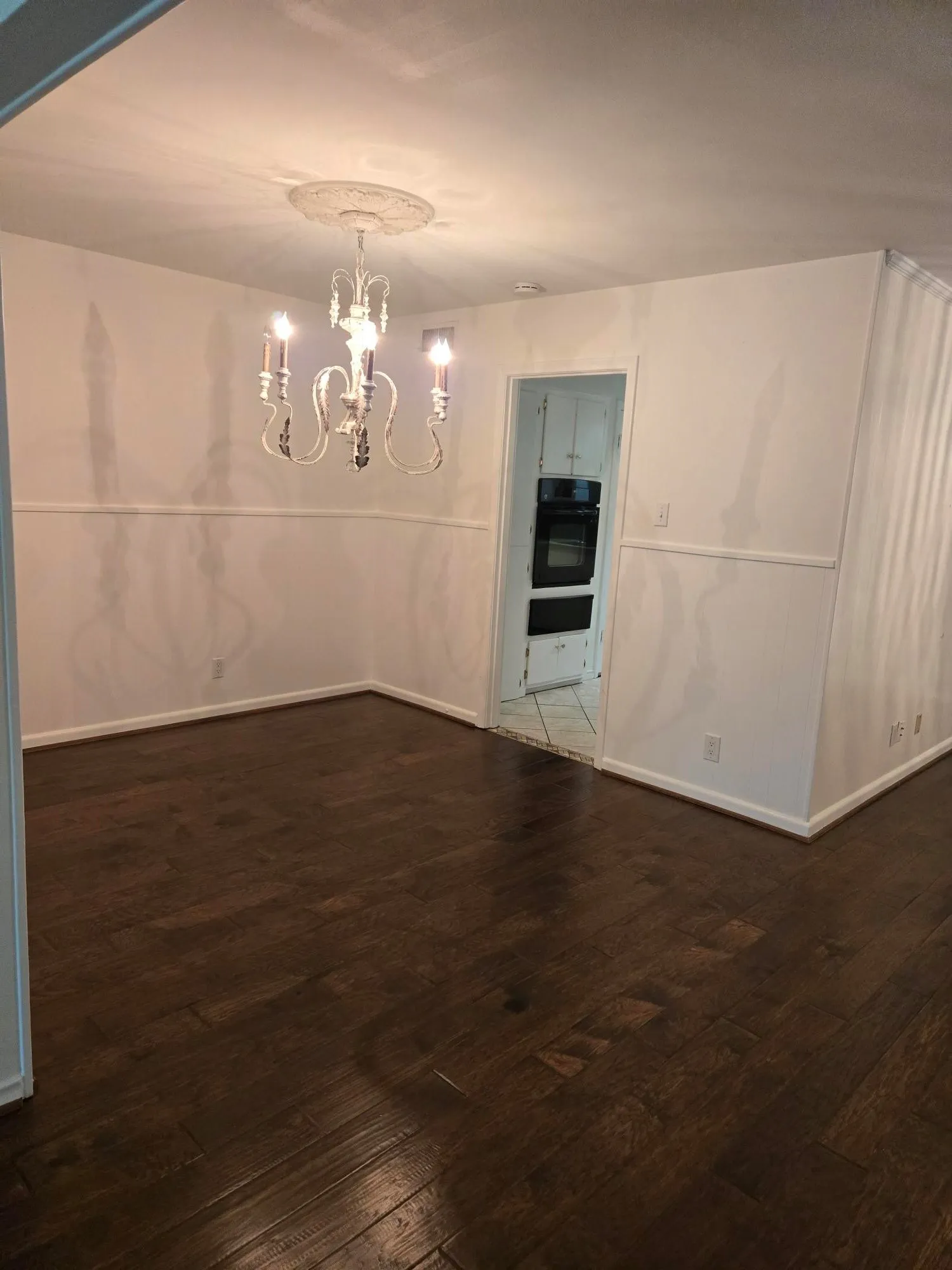Dark wood-finish flooring with white baseboards