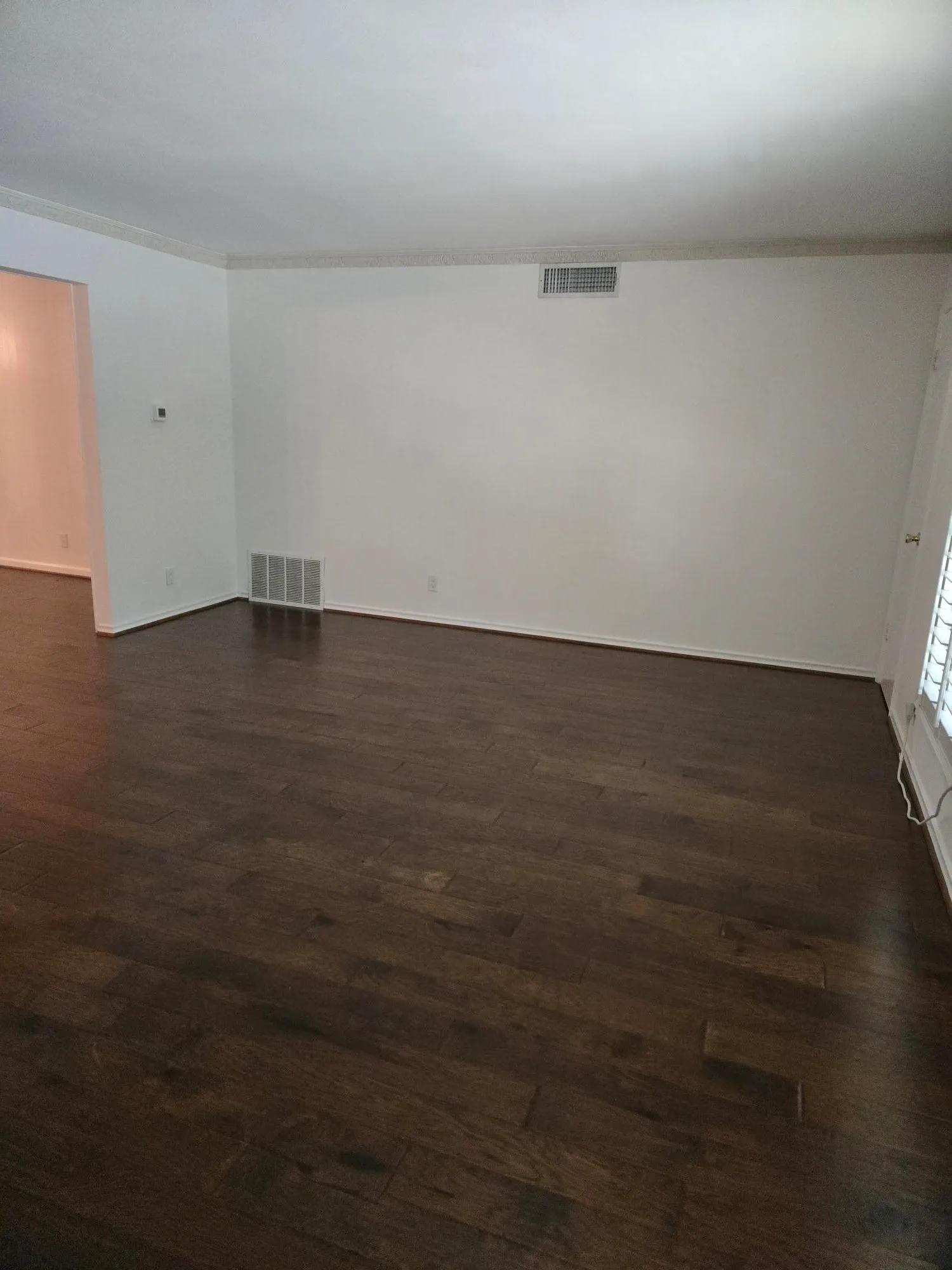 Dark wood-finish flooring with white baseboards