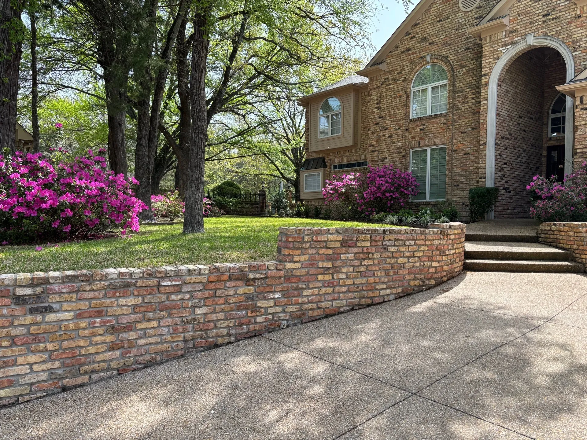 View of side of home with brick siding and a lawn