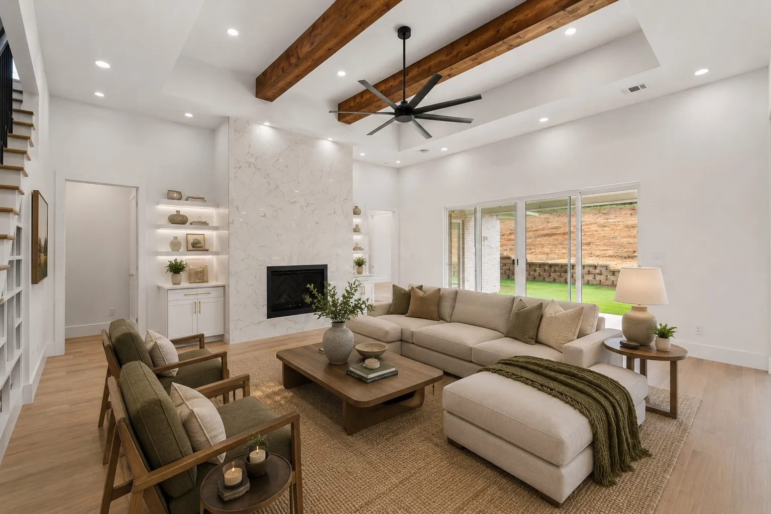 Spacious living area featuring a tray ceiling with exposed wood beams, a contemporary ceiling fan, and recessed lighting