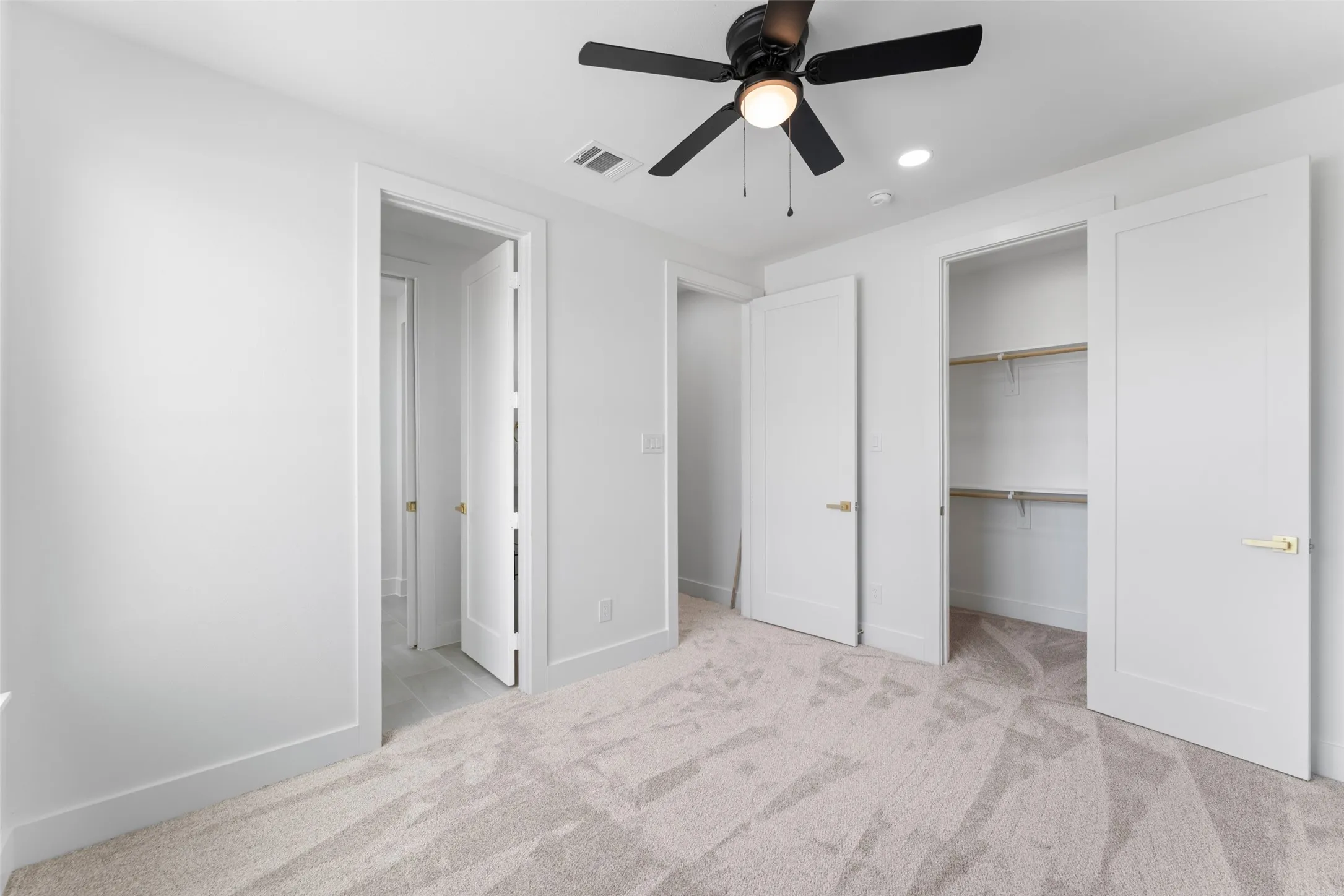 Unfurnished bedroom with light carpet, ceiling fan, and recessed lighting