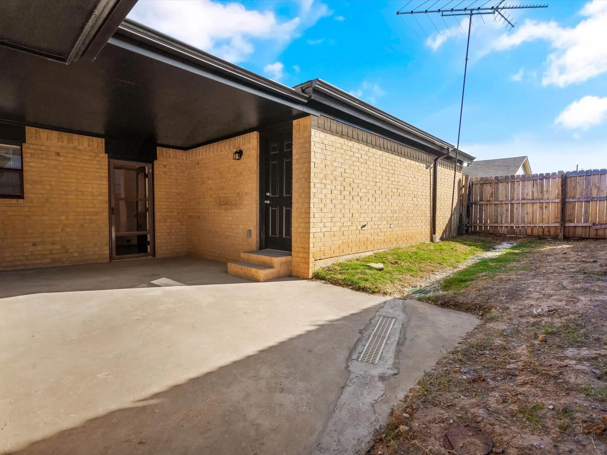 Entrance to property featuring a patio and brick siding