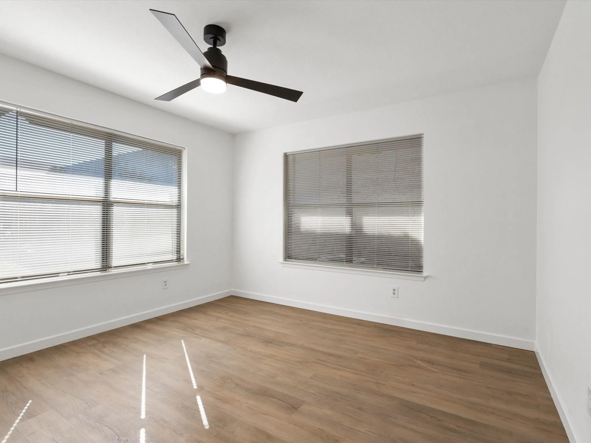 Spare room with wood finished floors and a ceiling fan