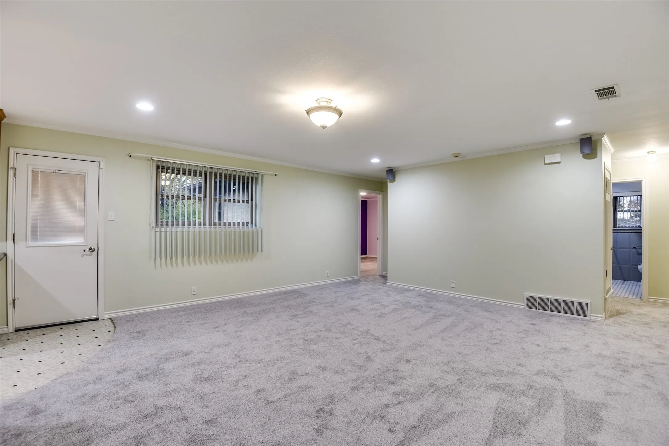 Carpeted empty room featuring crown molding and recessed lighting