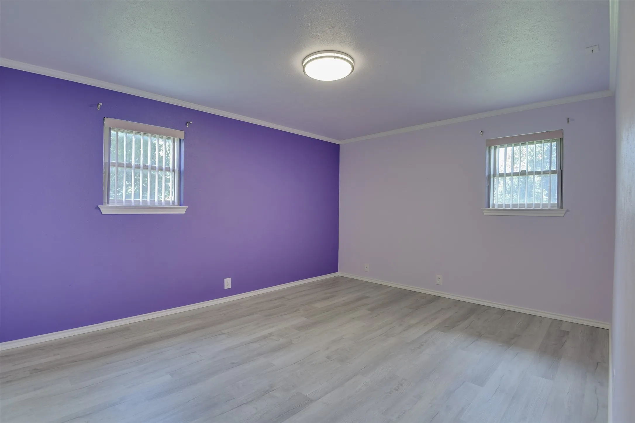 Empty room with ornamental molding and wood finished floors