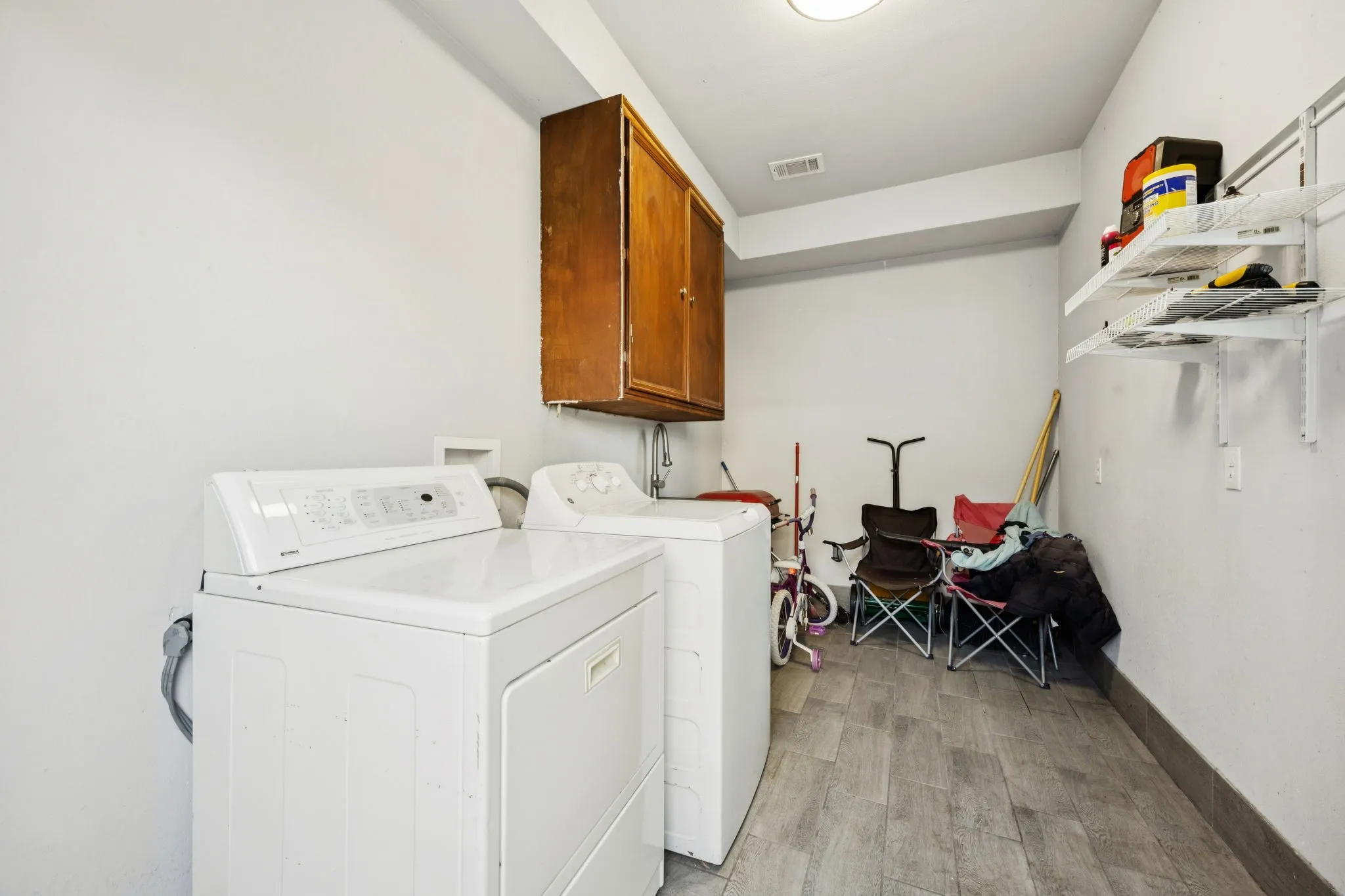 Laundry room with cabinet space, washing machine and clothes dryer, and wood finish floors