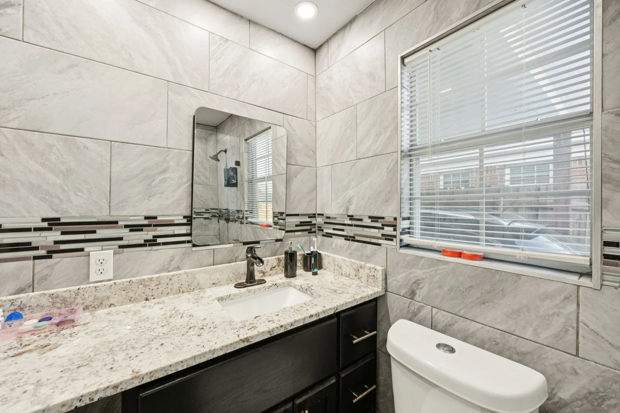 Bathroom featuring vanity, tile walls, and tiled shower