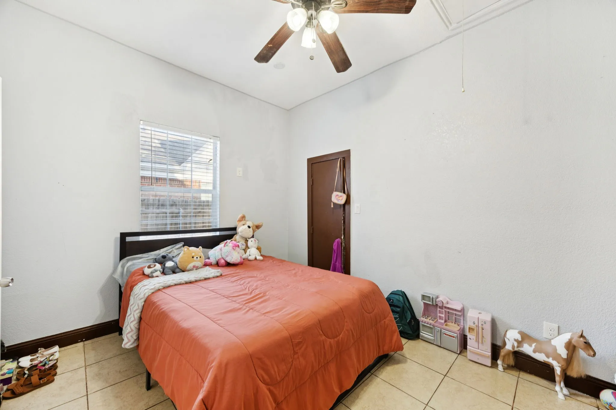 Bedroom with attic access, ceiling fan, and light tile patterned​​‌​​​​‌​​‌‌​‌‌​​​‌‌​‌​‌​‌​​​‌​​ floors