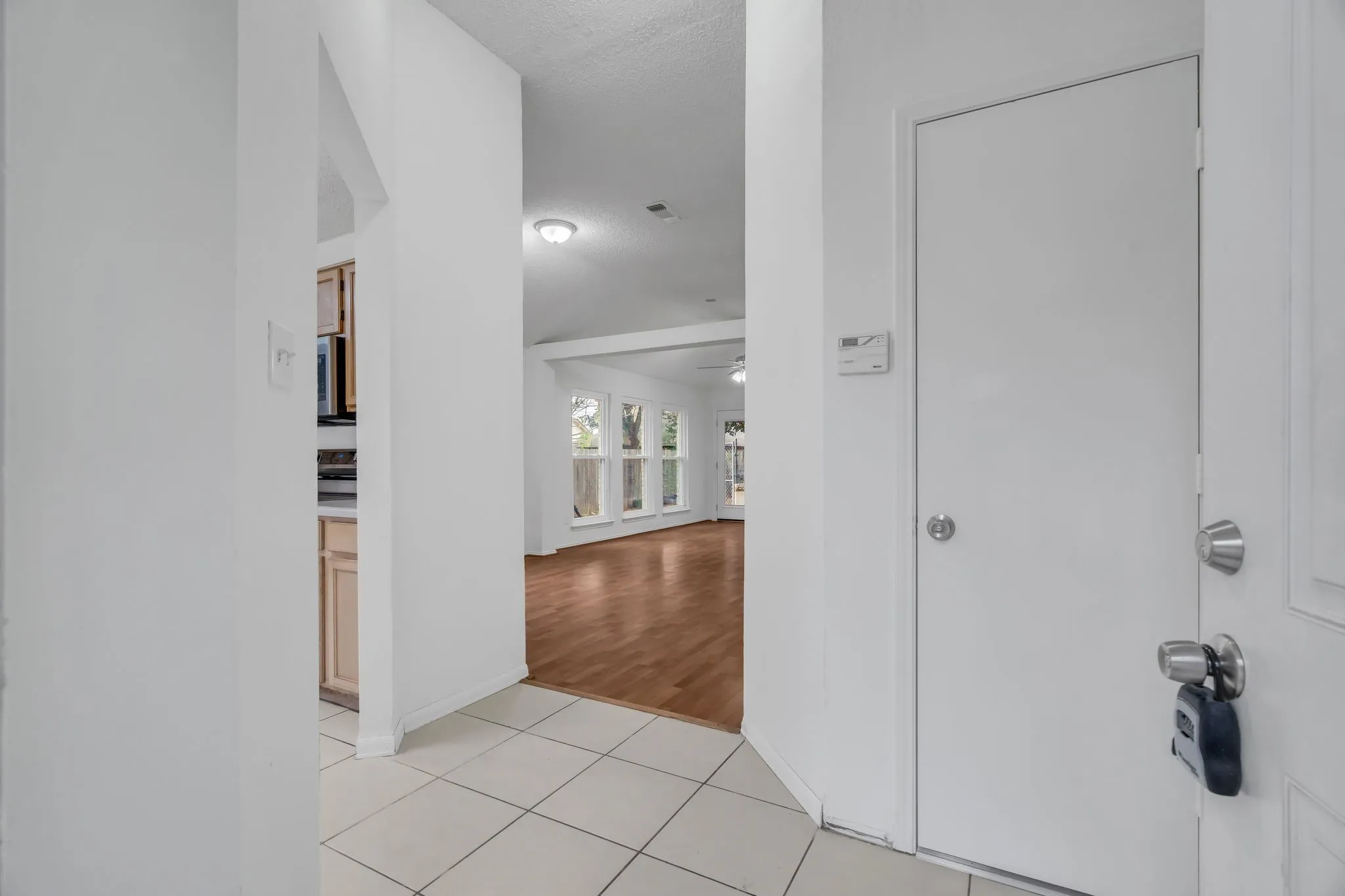 Corridor featuring light tile patterned floors and a textured ceiling