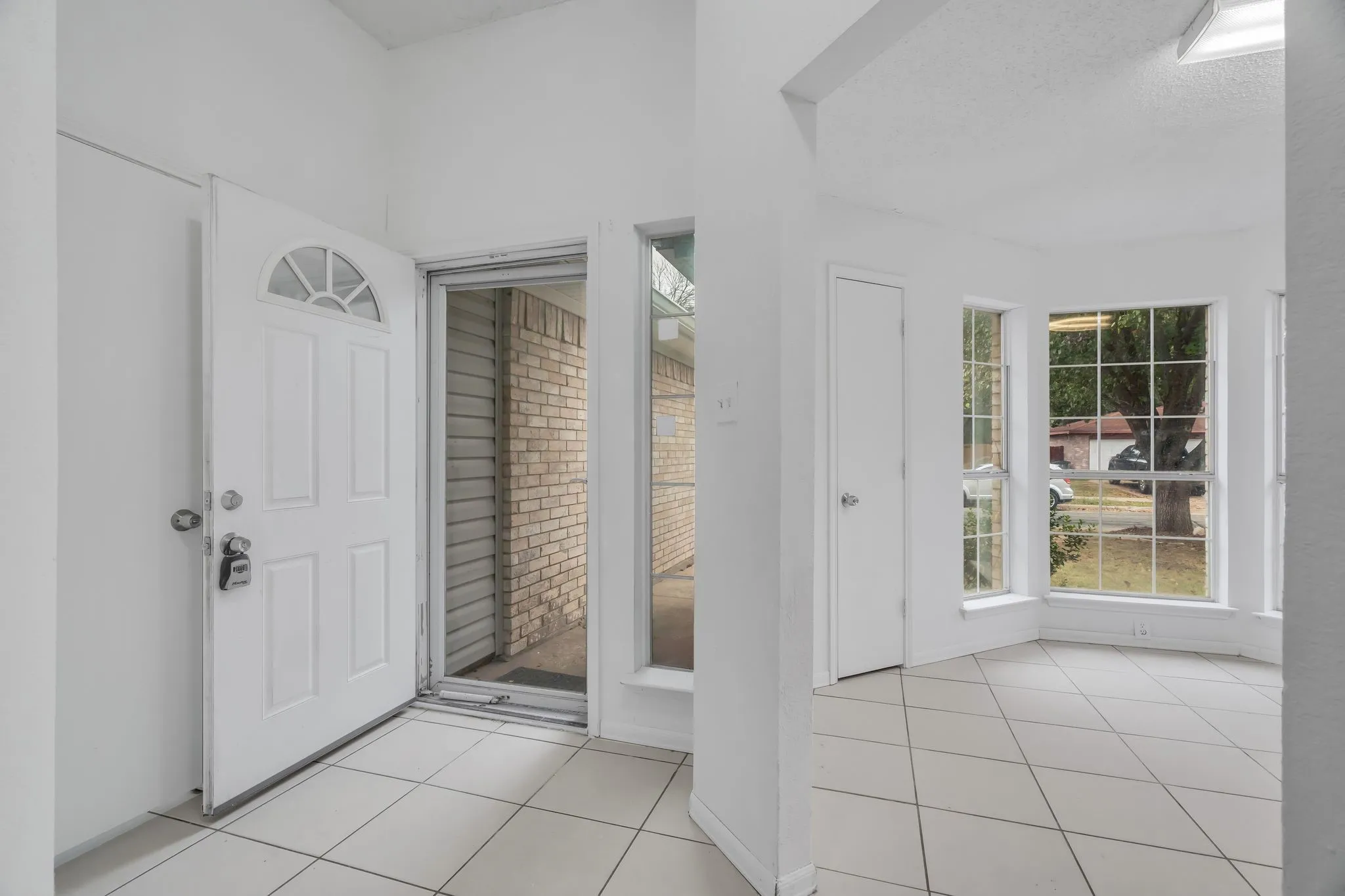 Foyer with light tile patterned floors and a textured ceiling