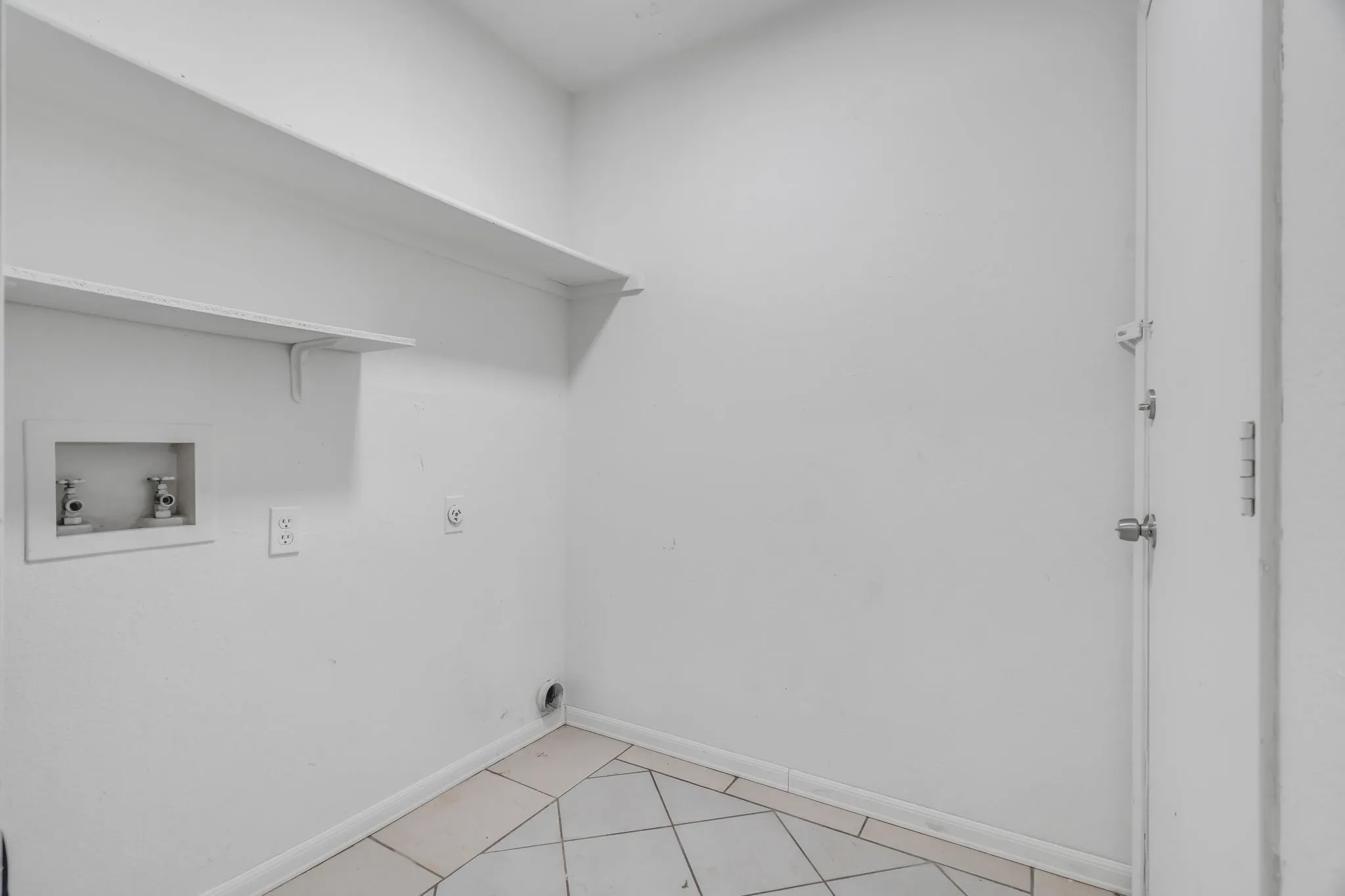 Laundry room with electric dryer hookup, washer hookup, and light tile patterned floors