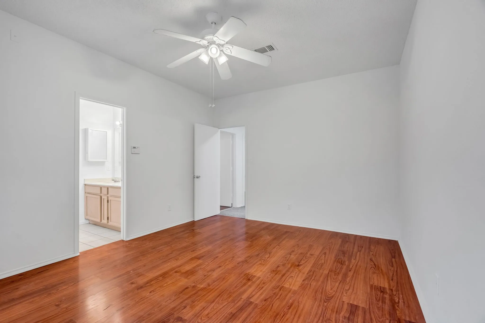 Unfurnished bedroom with light wood-style floors and a ceiling fan