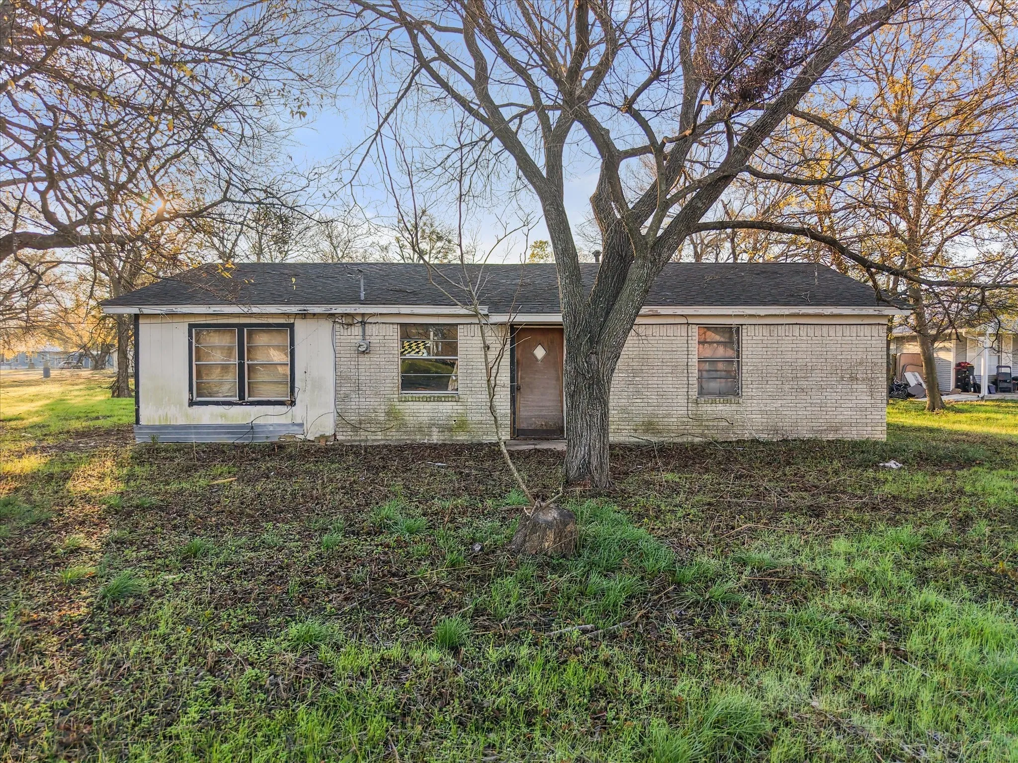 View of front of property featuring brick siding and a shingled roof