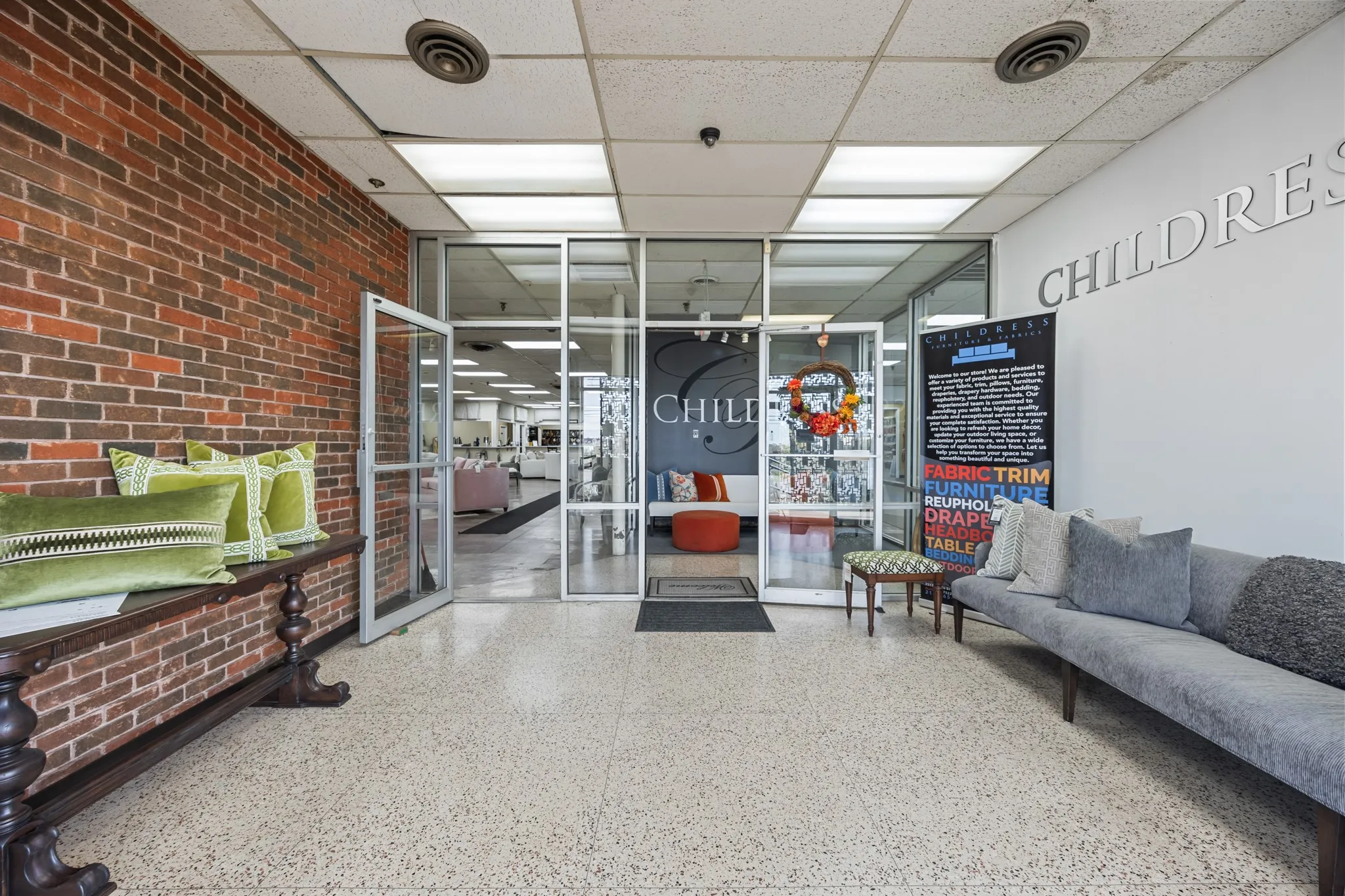 Building lobby featuring brick wall and a drop ceiling