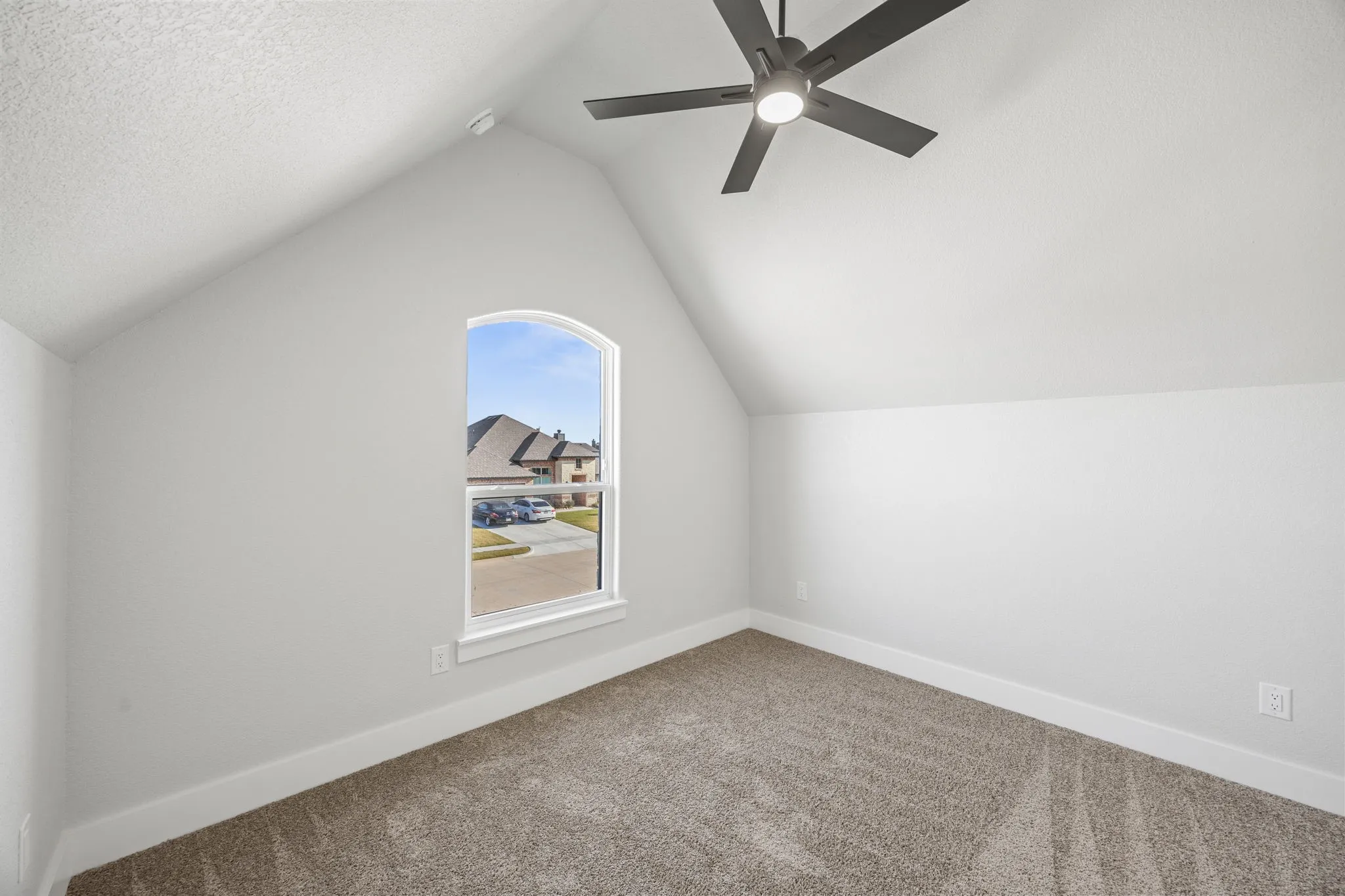 Additional living space with carpet floors, vaulted ceiling, and a textured ceiling