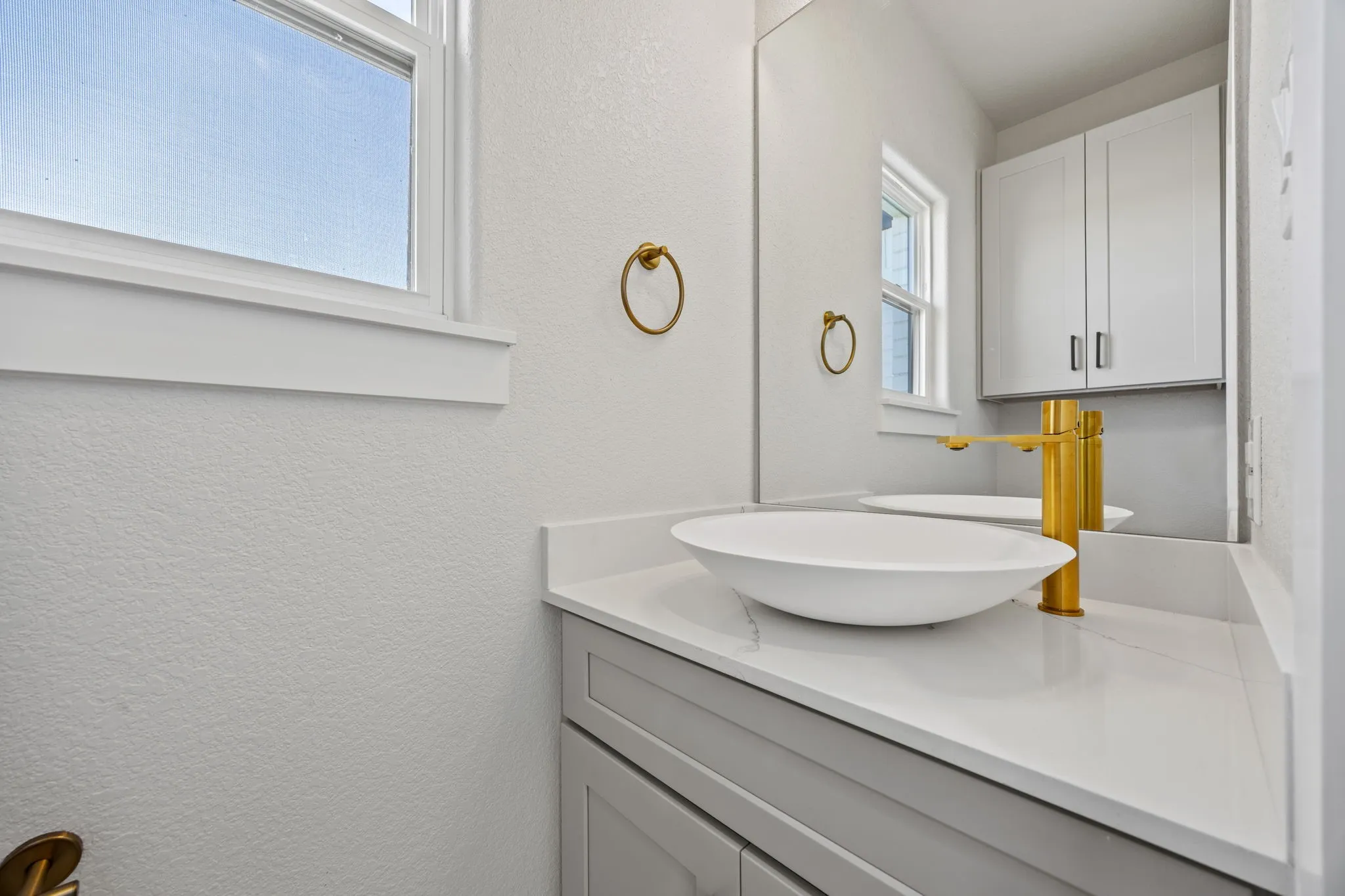 Bathroom featuring a textured wall and vanity