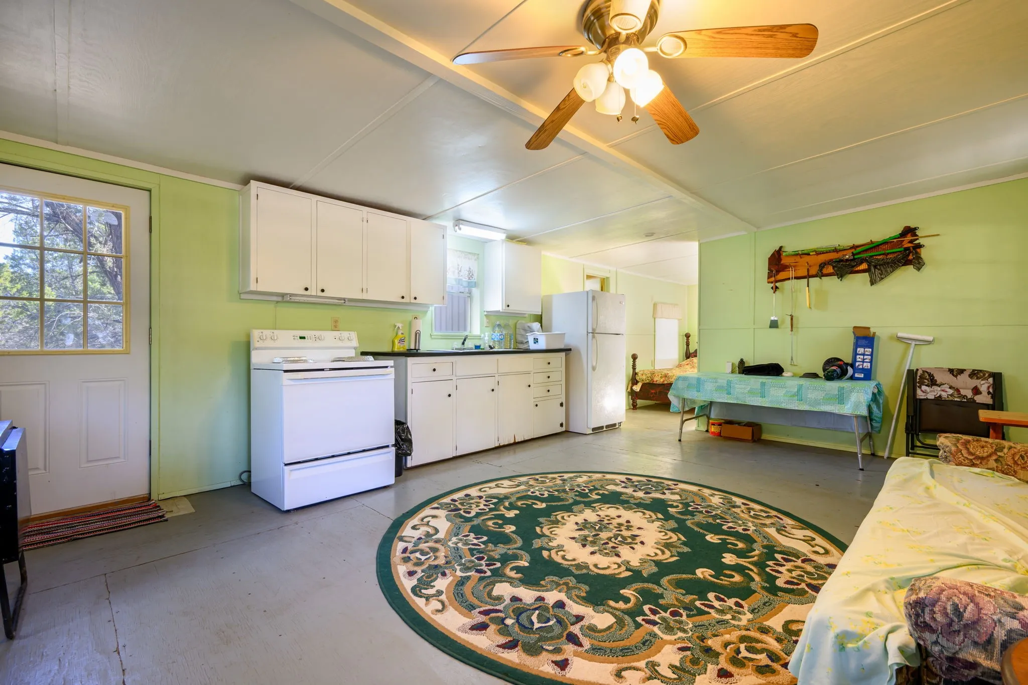 Kitchen featuring white cabinets, white appliances, and concrete floors