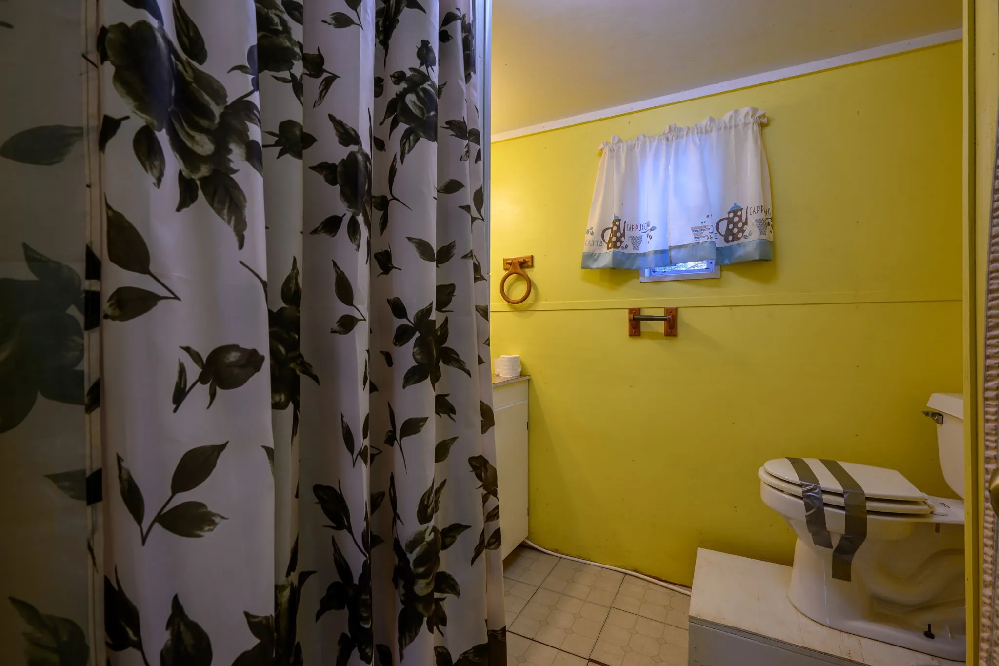 Full bathroom featuring a shower with shower curtain, vanity, and light tile patterned floors