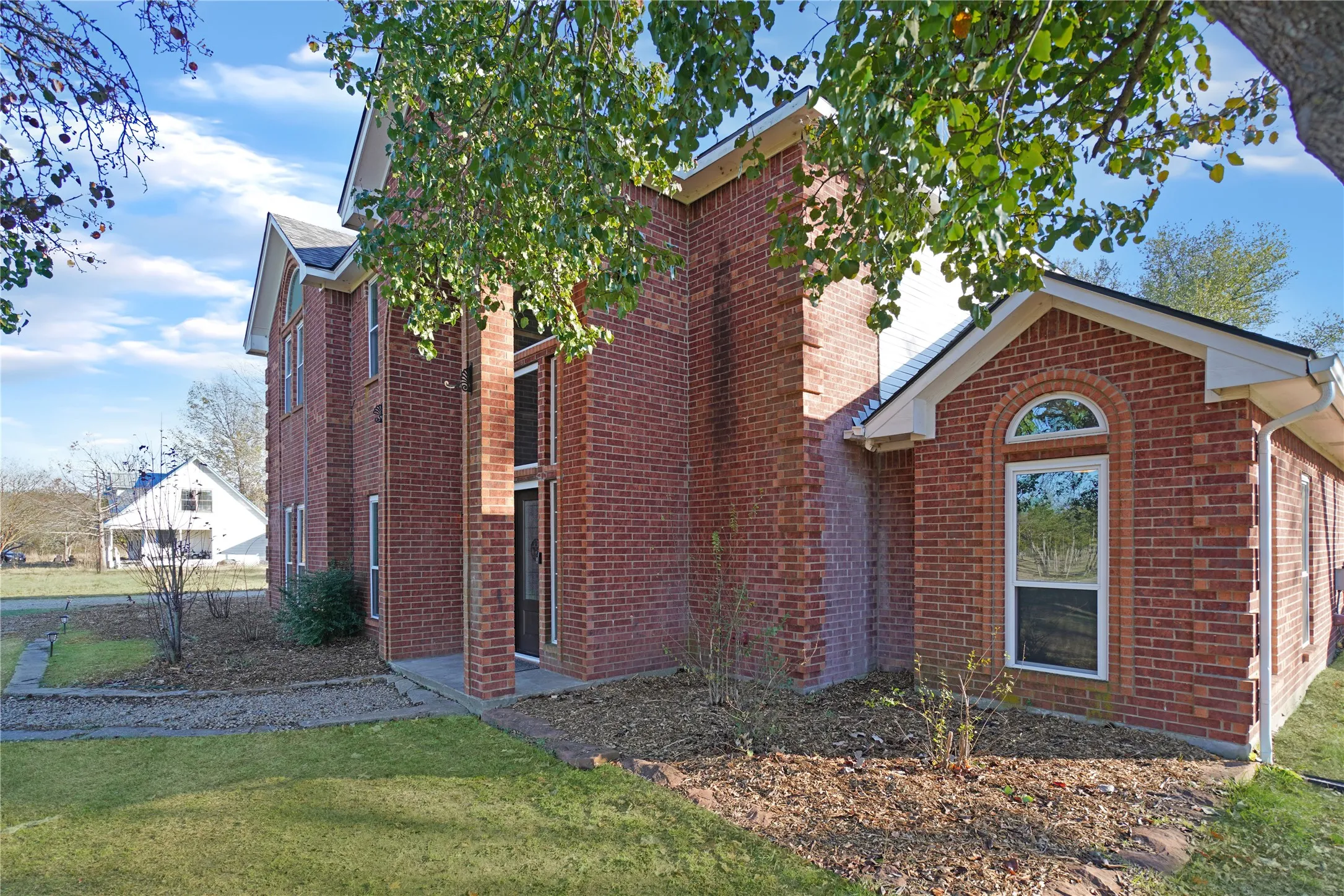 View of home's exterior featuring brick siding and a lawn