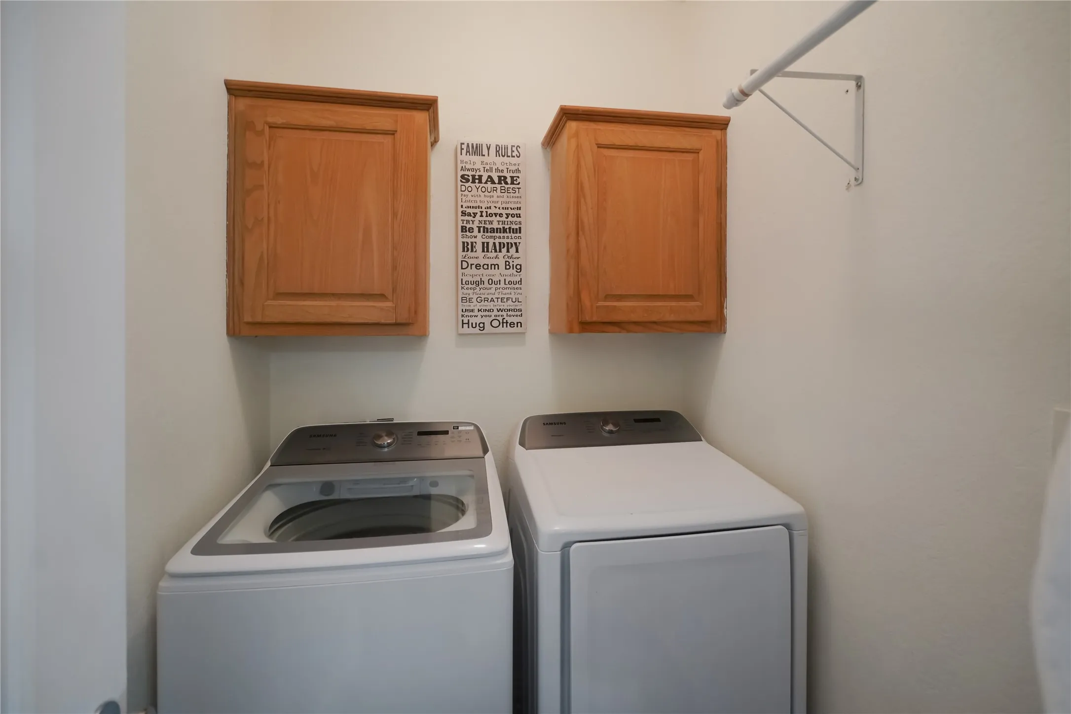 Washroom with washer and clothes dryer and cabinet space
