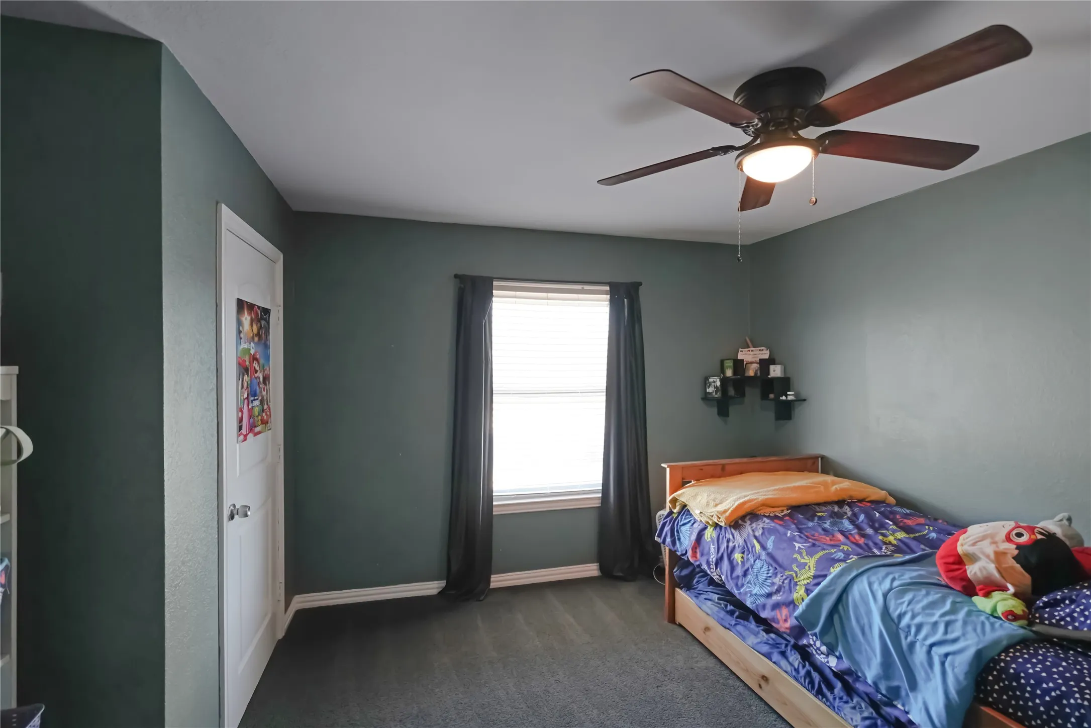 Bedroom with dark colored carpet and ceiling fan