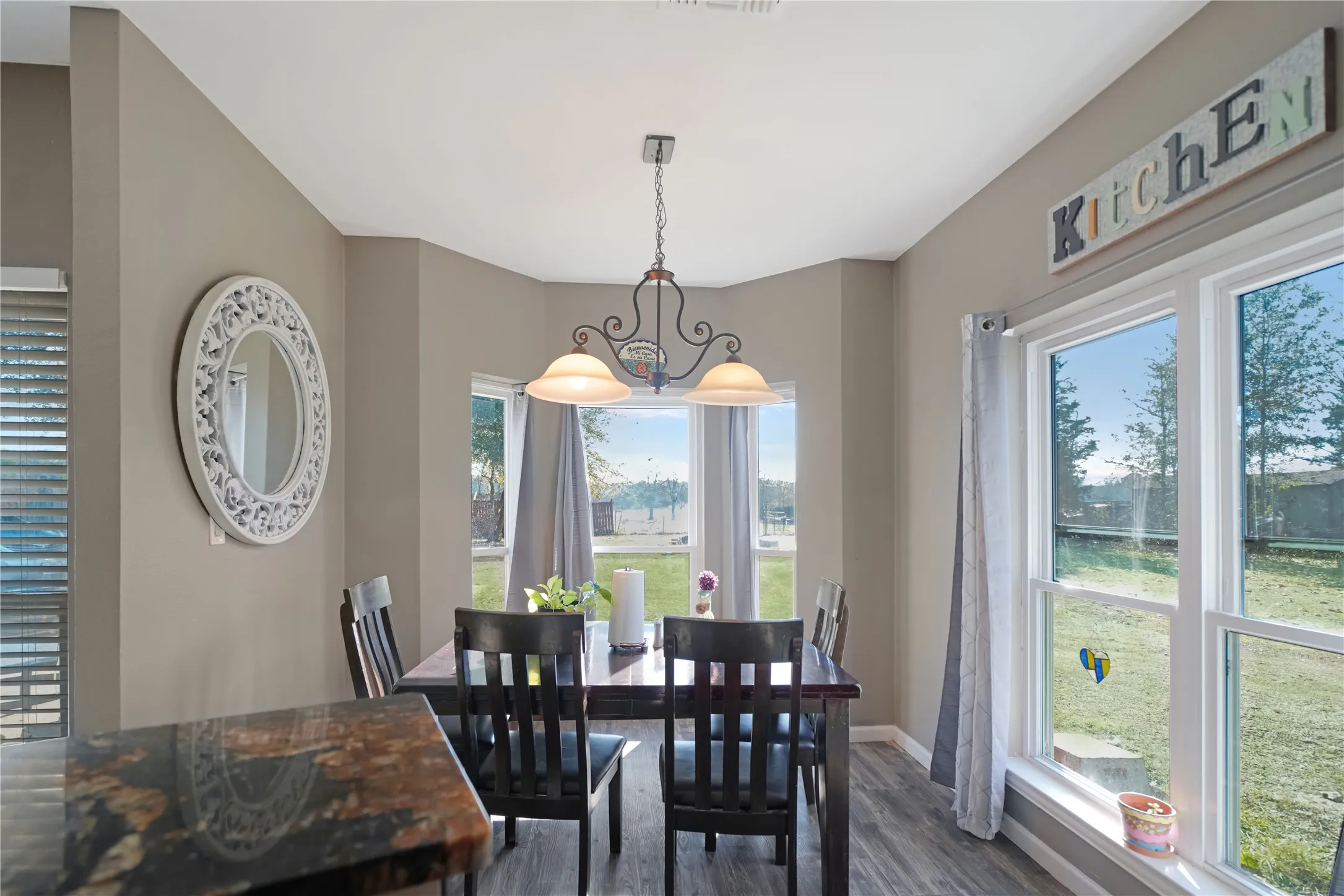 Dining room with dark wood-style flooring and baseboards