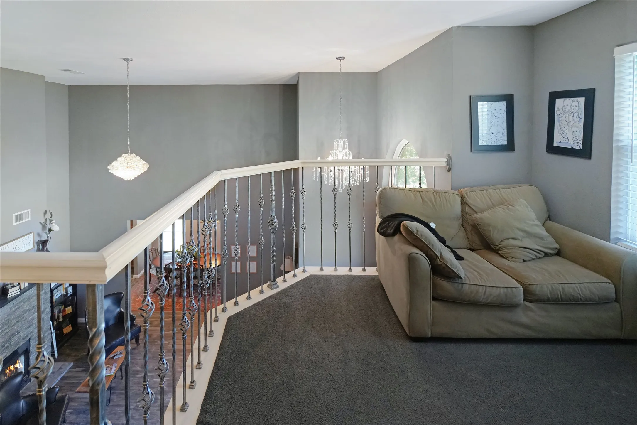 Living area featuring plenty of natural light, a chandelier, and an upstairs landing