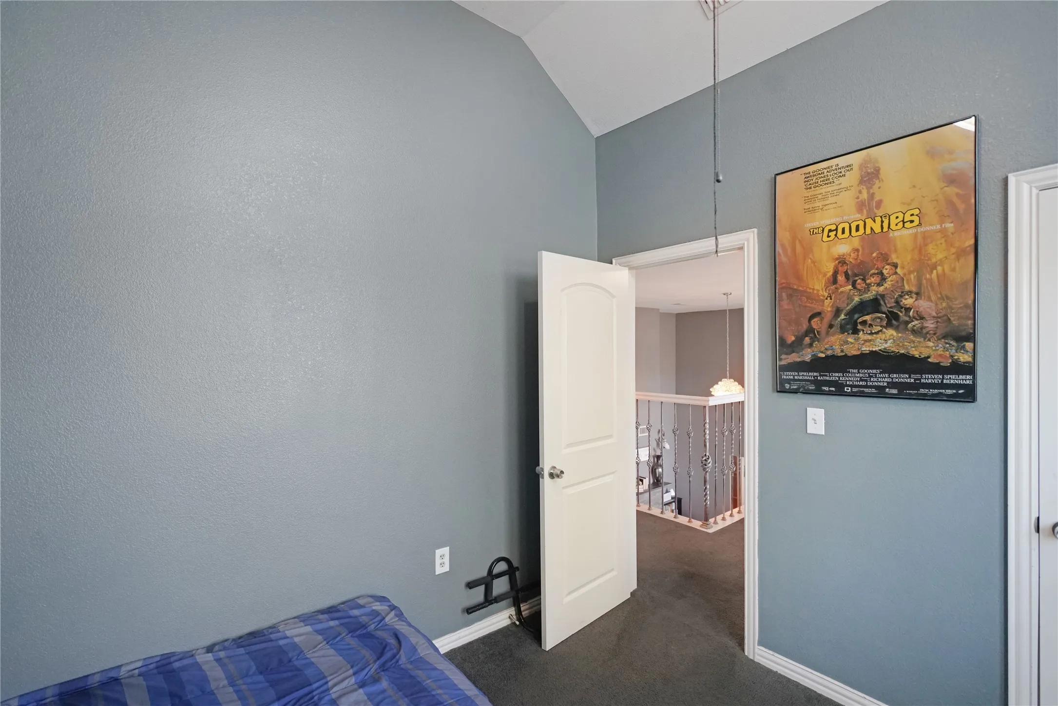 Unfurnished bedroom with vaulted ceiling and dark carpet