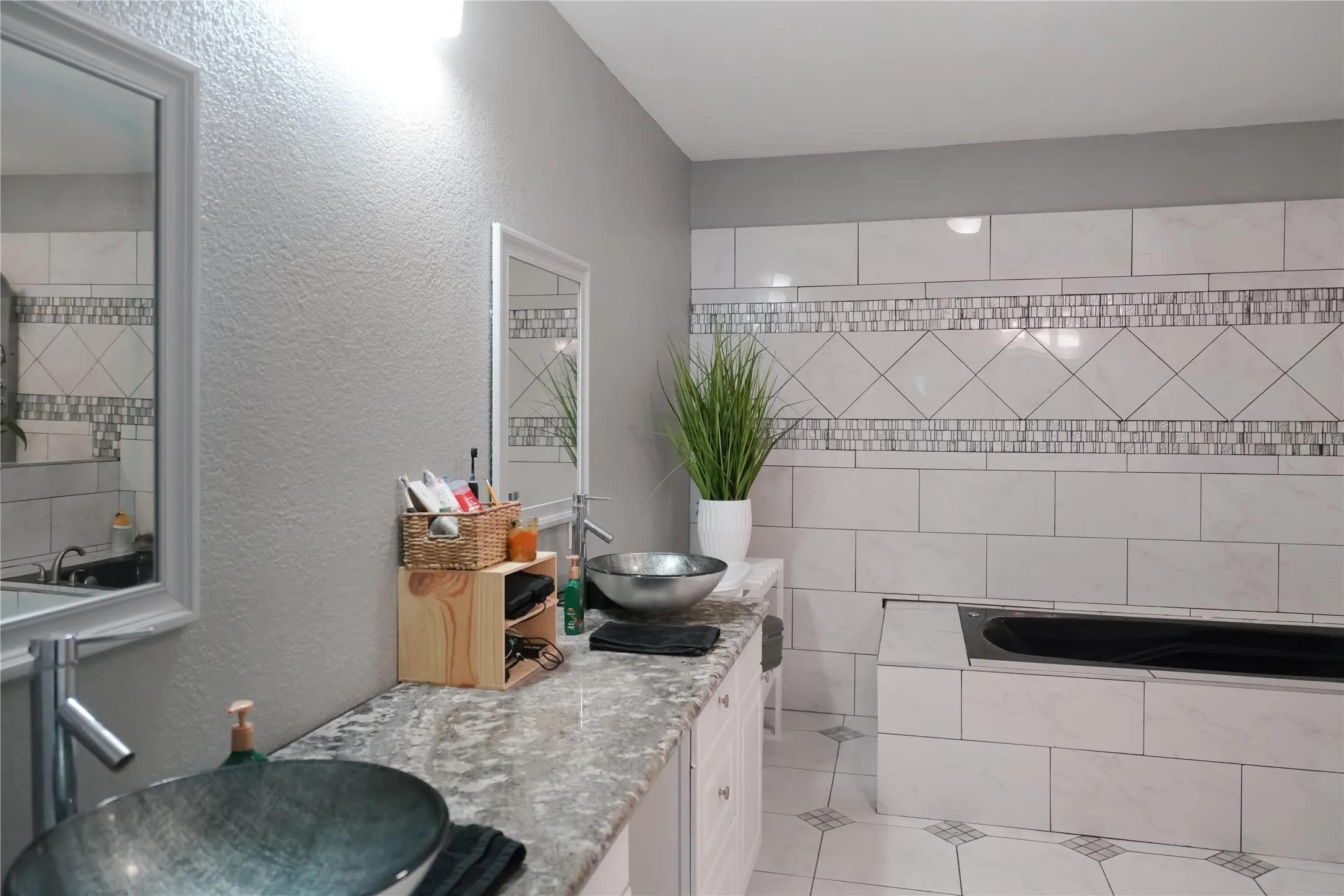 Bathroom featuring a textured wall and double vanity