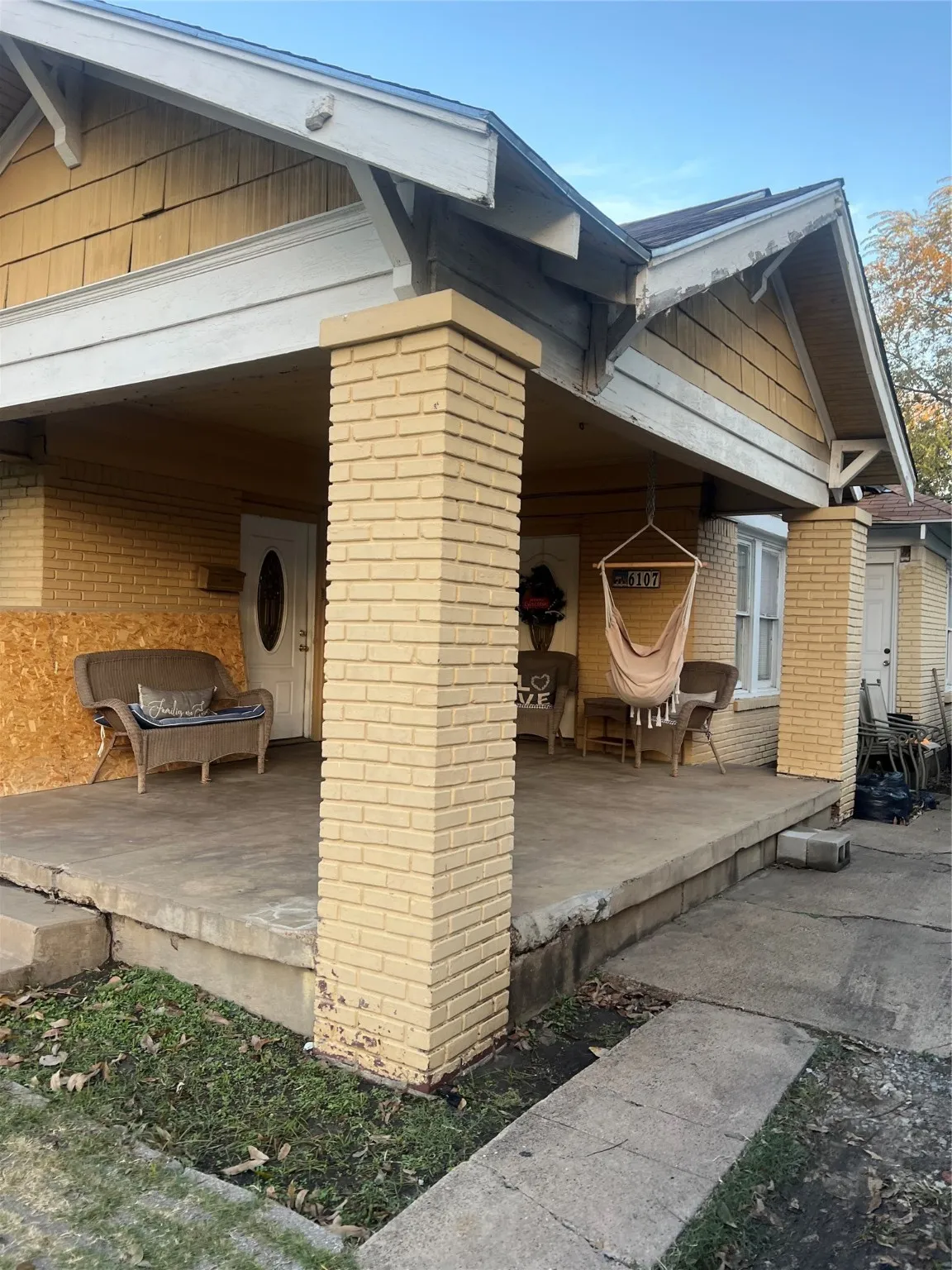 View of side of property featuring brick siding and a porch