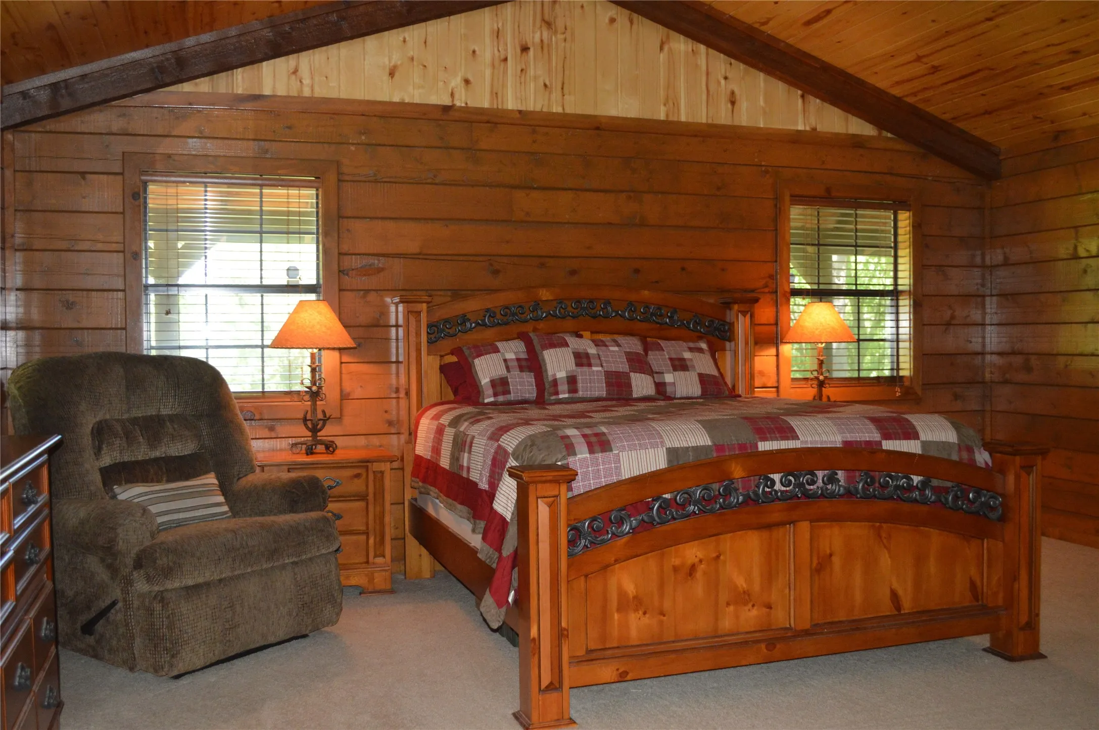 Bedroom featuring carpet, wooden ceiling, wood walls, and multiple windows