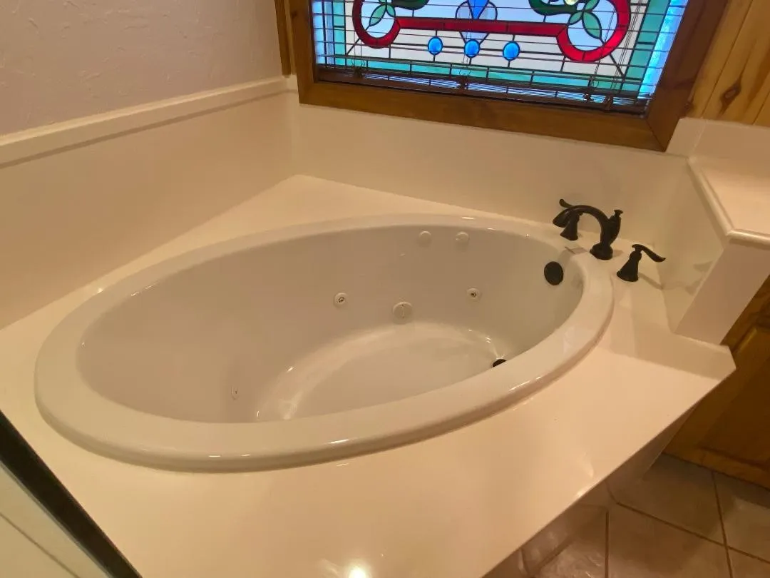 Bathroom with a tub with jets and tile patterned flooring