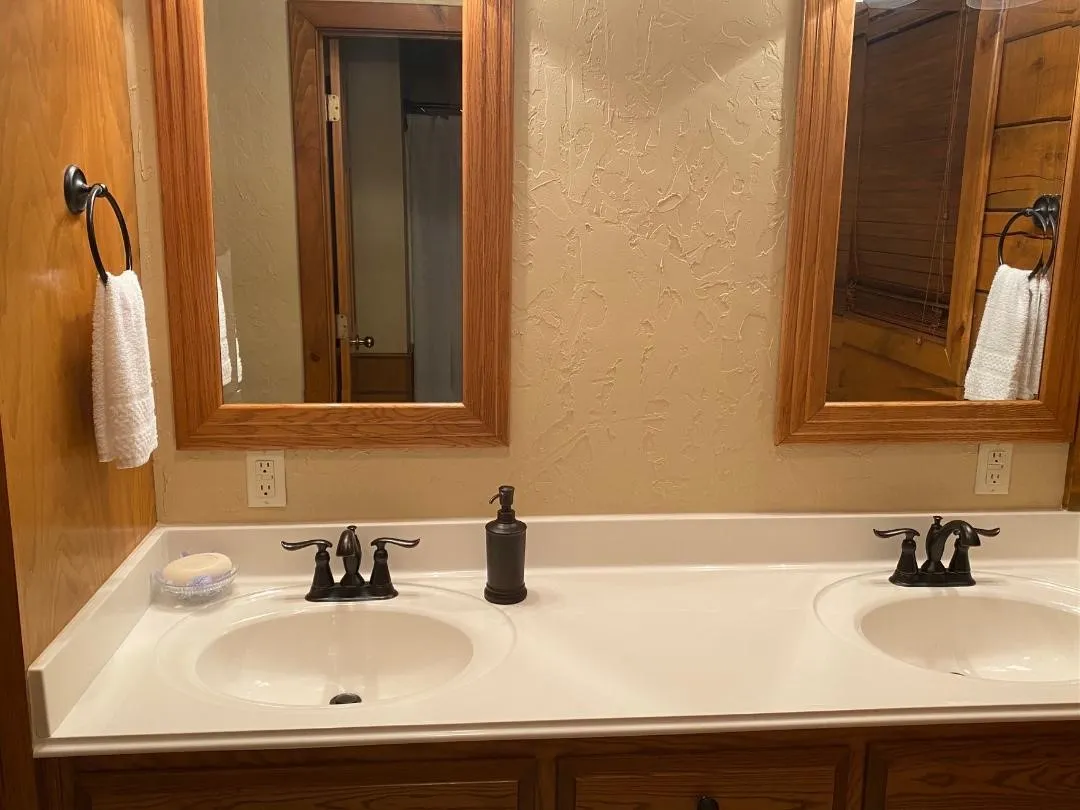 Bathroom featuring a textured wall and double vanity