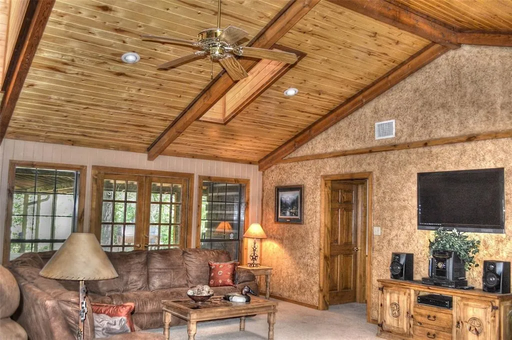 Living area featuring light colored carpet, a wooden ceiling with exposed beams, french doors, high vaulted ceiling, and a ceiling fan