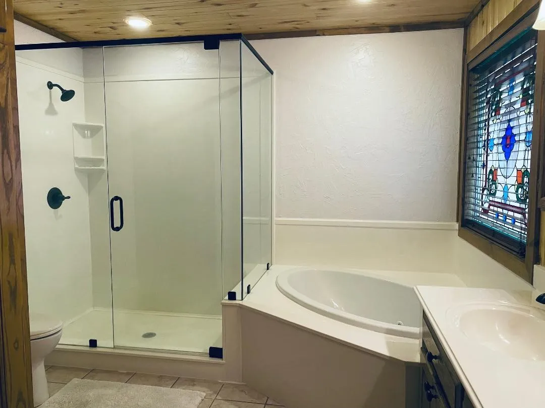 Bathroom with wood ceiling, a garden tub, vanity, a shower stall, and a textured wall