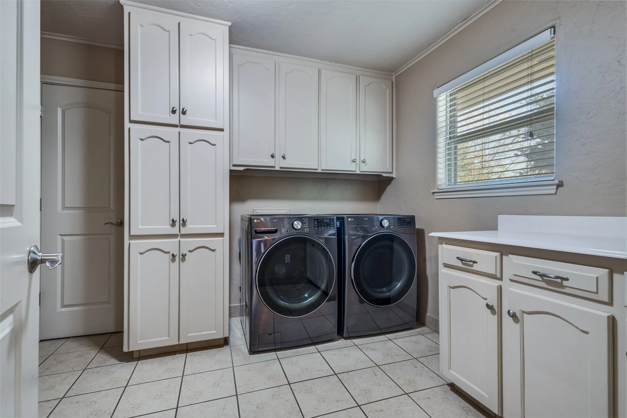 this is a very nice laundry room with room for a freezer and access to a half bath left