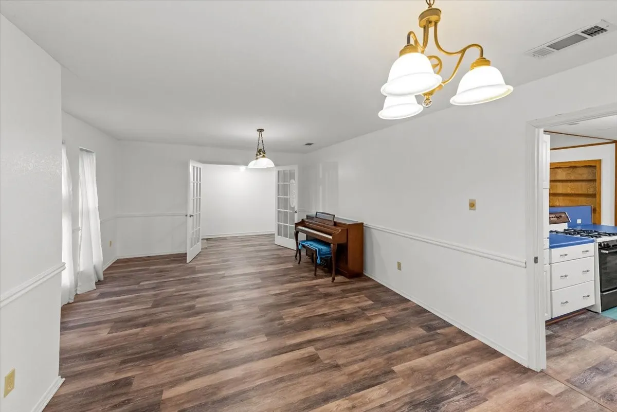 Unfurnished formal dining and living  area with vinyl floors and french​​‌​​​​‌​​‌‌​‌‌​​​‌‌​‌​‌​‌​​​‌​​ doors