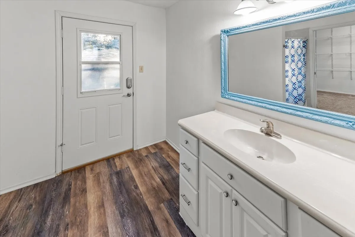 Primary bathroom featuring vanity, vinyl floors, and a shower with curtain