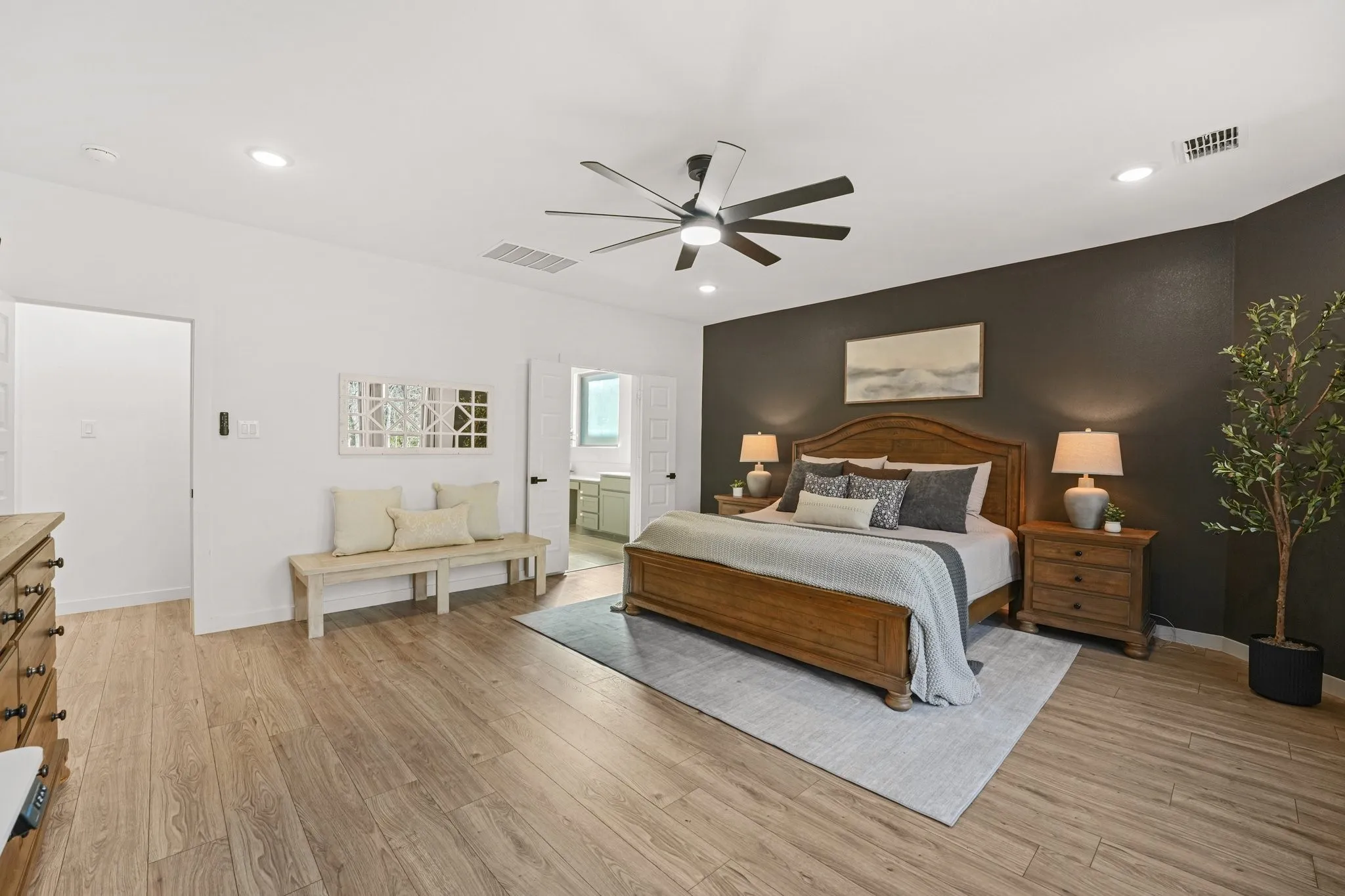 Bedroom with light wood-style flooring, ceiling fan, an accent wall, and recessed lighting