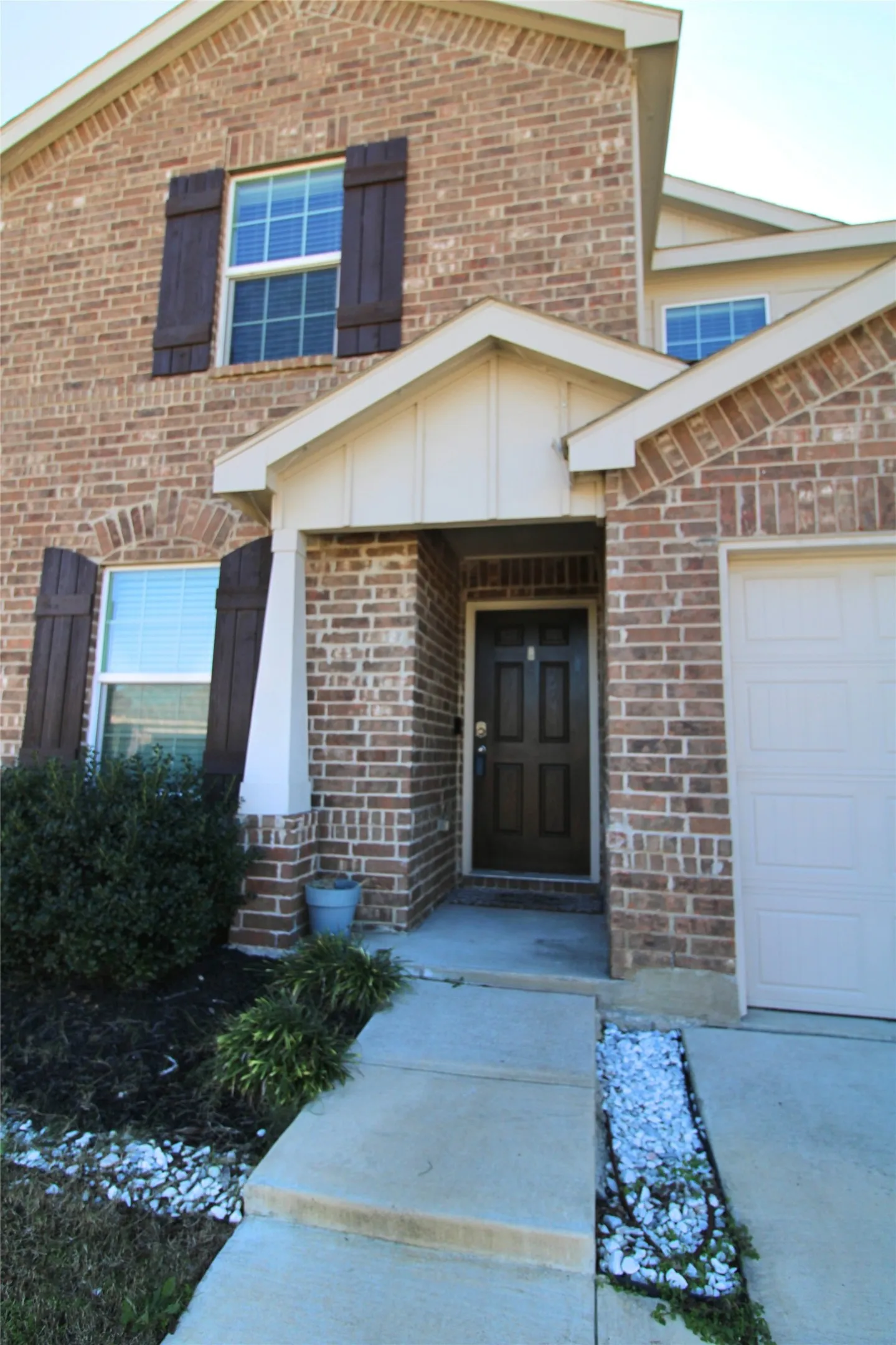 Entrance to property featuring brick siding and an attached garage