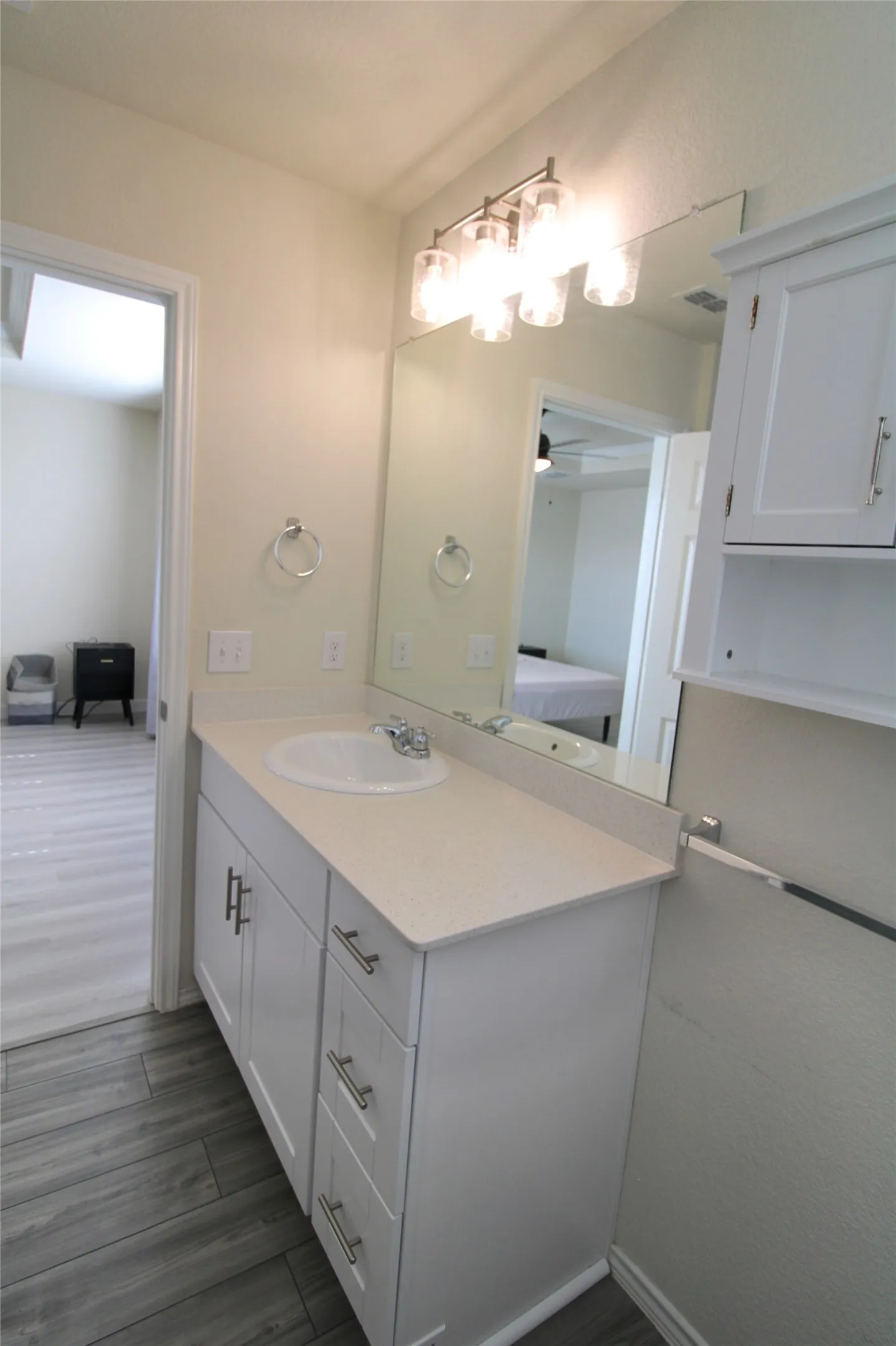 Bathroom with vanity, dark wood-style floors, a ceiling fan, and ensuite bath