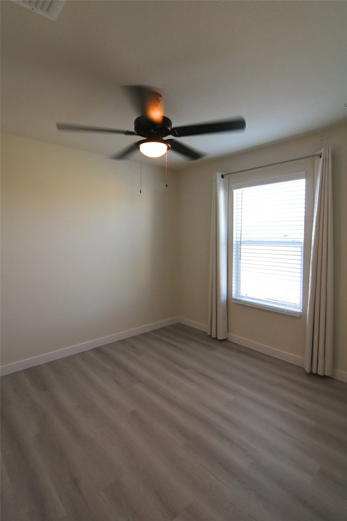 Spare room featuring wood finished floors and ceiling fan